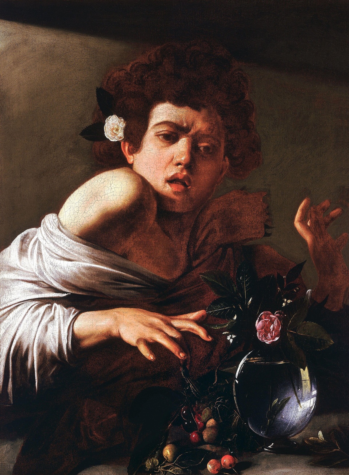 Boy bitten by a Lizard, by Caravaggio: a youth with a rose in his hair jerks back his hand from a bowl of fruit.