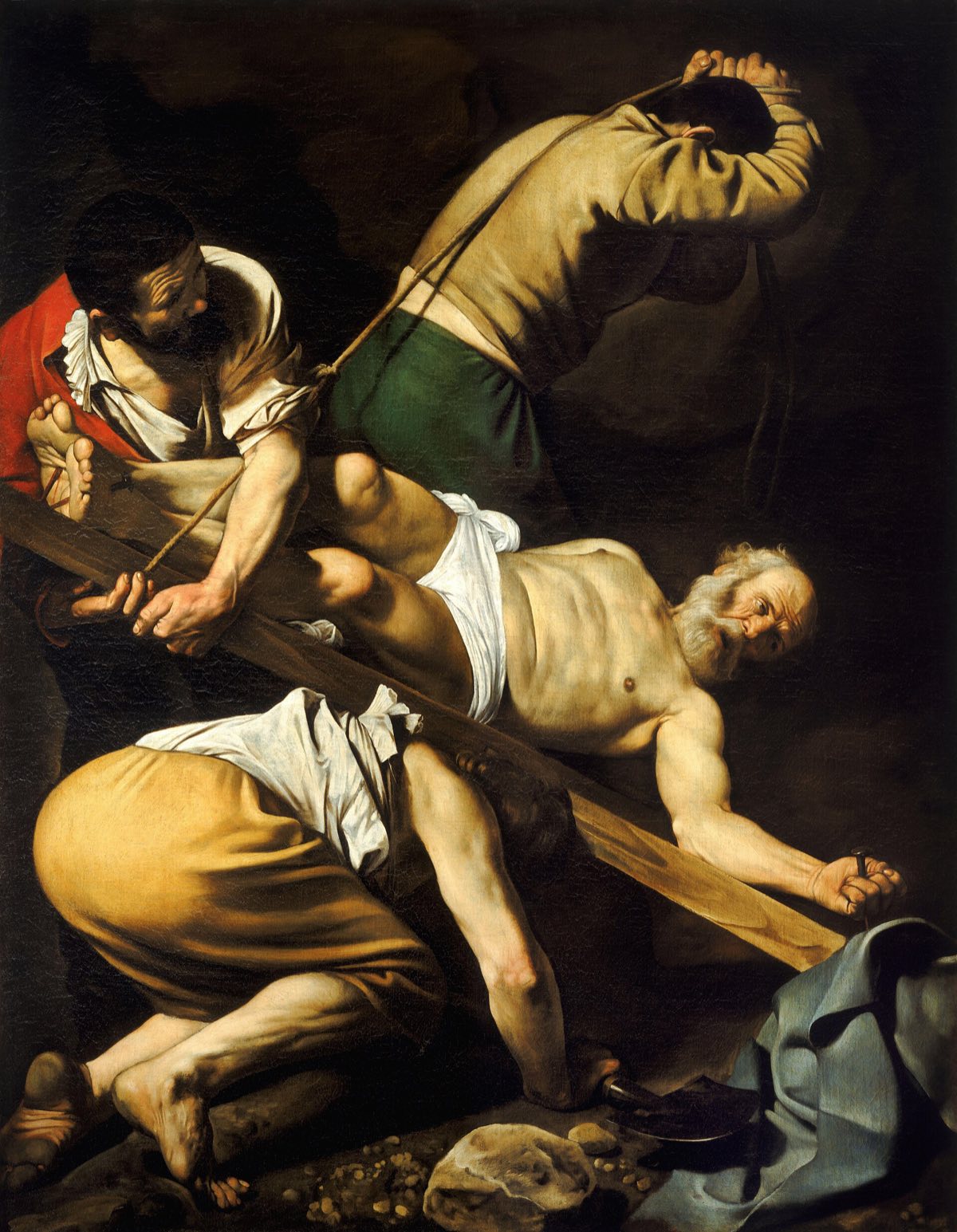 The Crucifixion of St Peter by Caravaggio: three workmen heave up the cross with the old saint nailed to it.