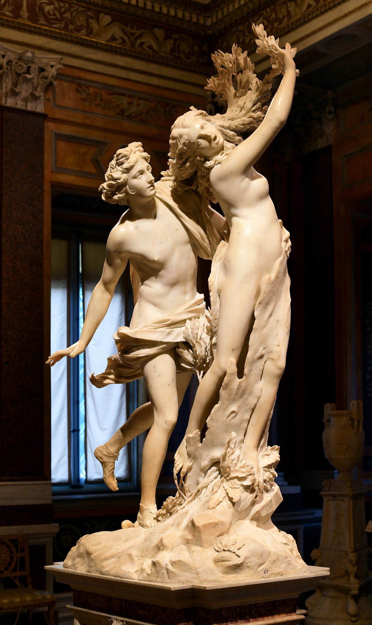 Apollo and Daphne by Bernini: the god reaches the nymph as her hands turn to leaves, in white marble.