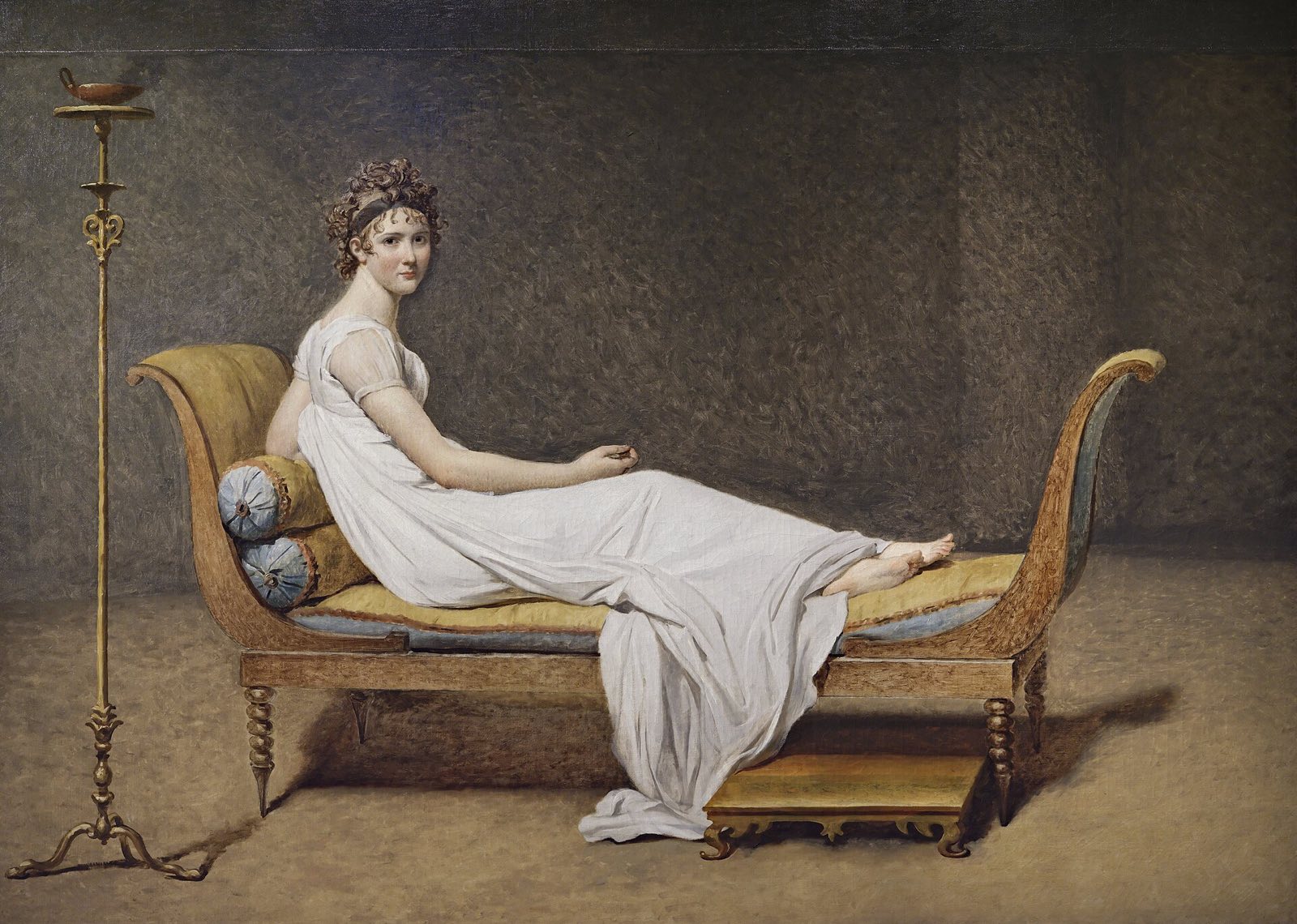 Portrait of Madame Récamier, by David: a woman in white reclining on a couch in a bare room.