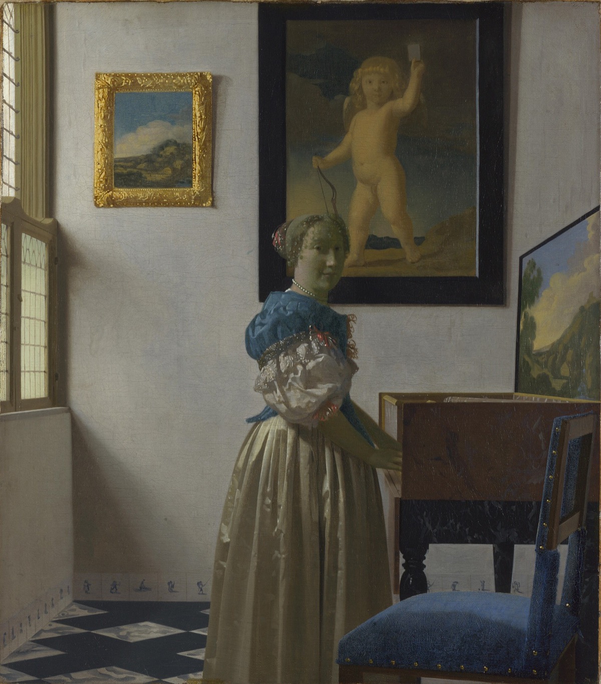 A Young Woman standing at a Virginal, by Vermeer: a woman in silk at a keyboard, with a picture of Cupid behind her.