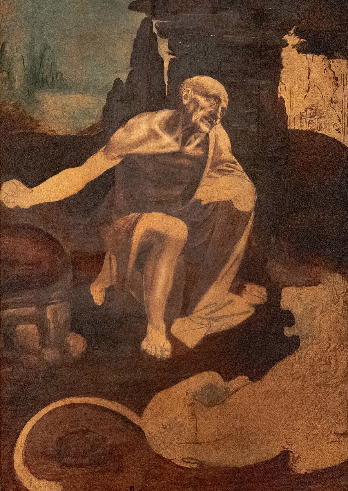 Saint Jerome in the Wilderness by Leonardo da Vinci: the gaunt saint kneeling among rocks with a lion at his feet, unfinished, in browns.