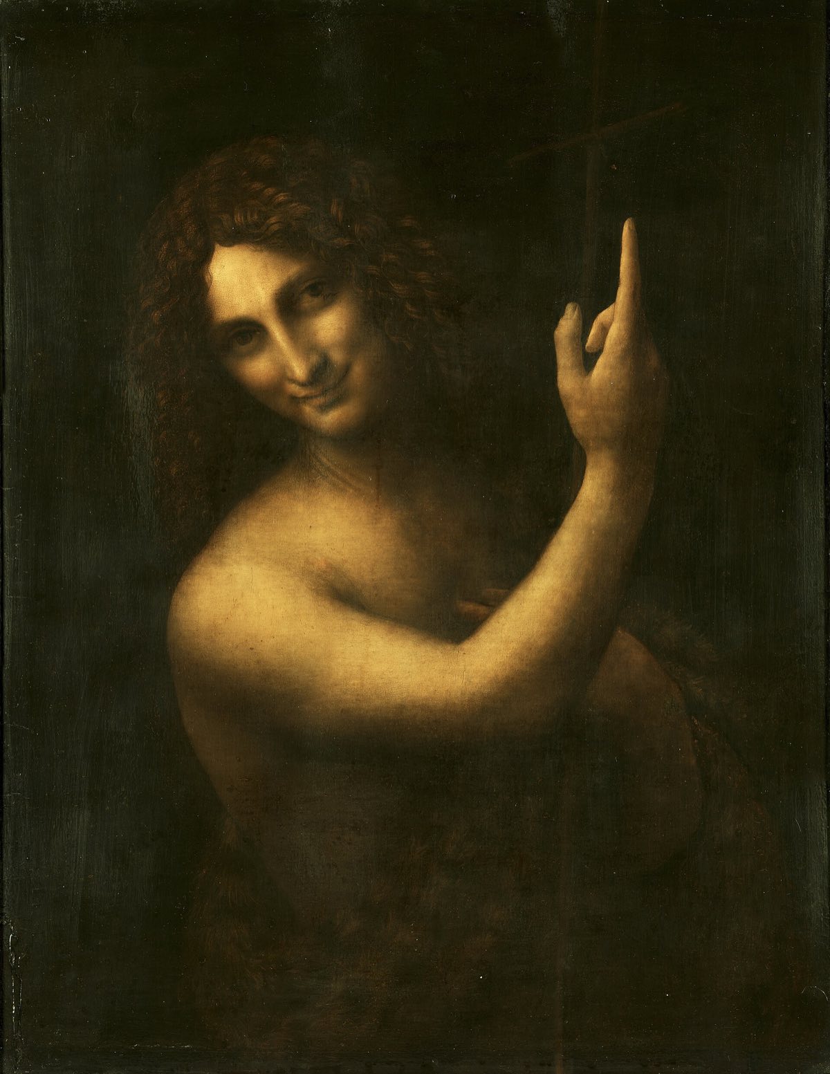 Saint John the Baptist, by Leonardo da Vinci: the saint smiling out of darkness, pointing upwards.
