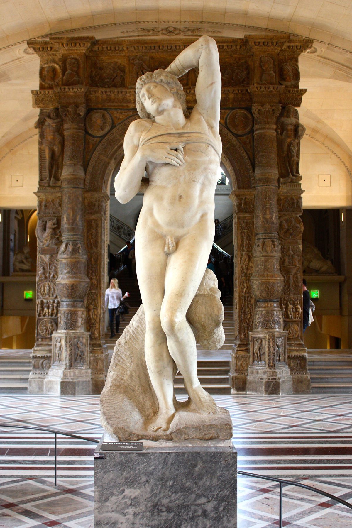 Michelangelo's Dying Slave in the Louvre, a marble figure of a young man with one arm raised behind his head.