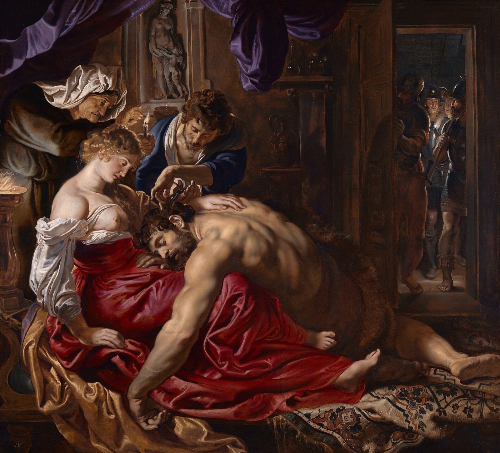 Samson and Delilah, by Rubens: Samson asleep across Delilah's lap by candlelight while a man cuts his hair.