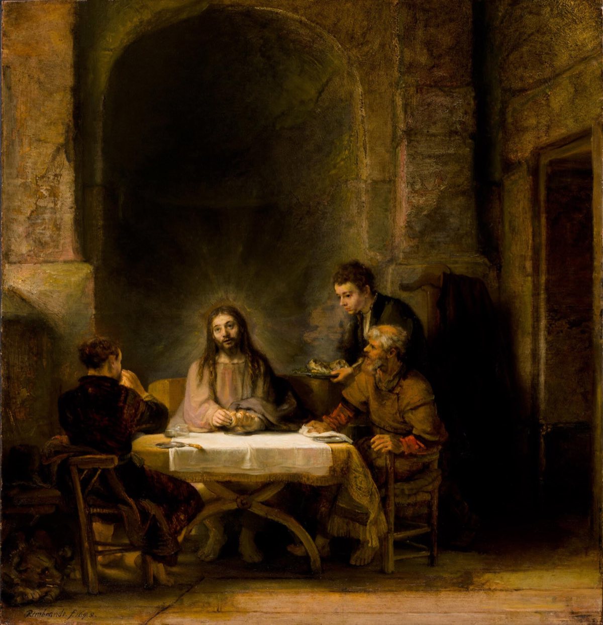 The Supper at Emmaus, by Rembrandt: Christ at a table before a tall stone niche, two disciples beside him.