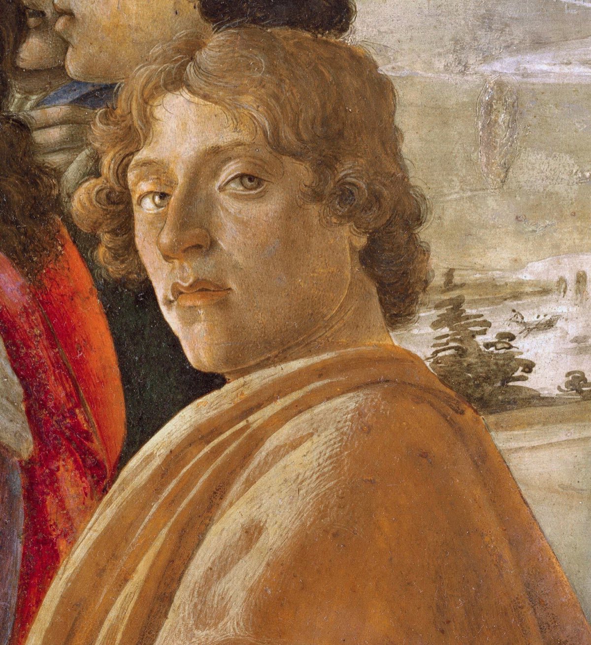 A young man in a yellow cloak looking out at the viewer, thought to be Botticelli's portrait of himself.