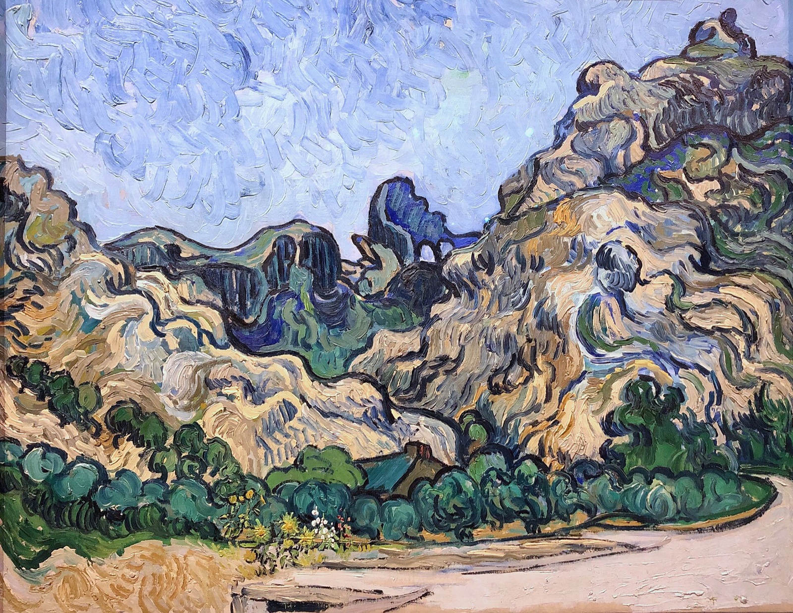 Mountains at Saint-Rémy, by Van Gogh: heaving blue and green hills above a small house and a path.