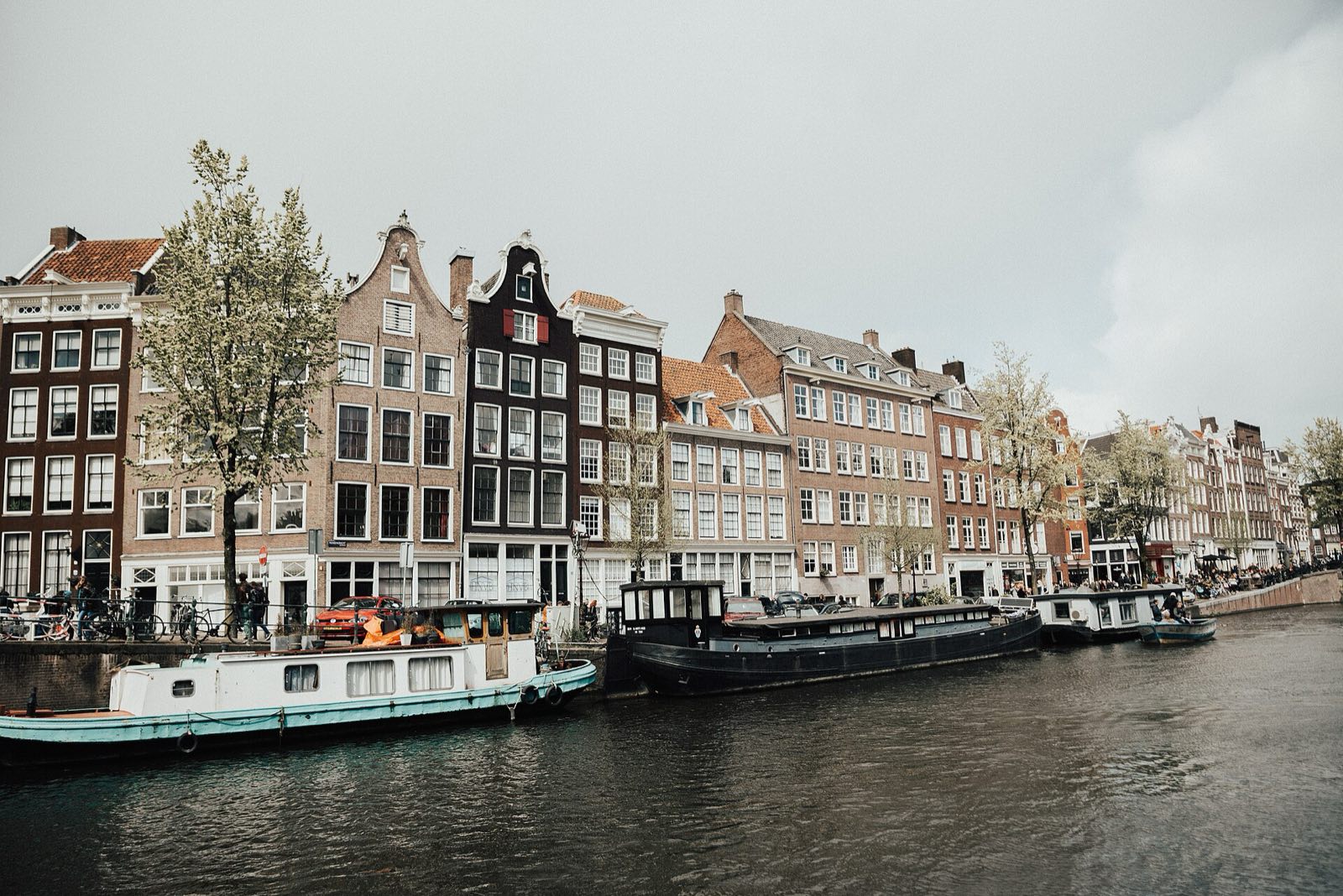 A row of narrow canal houses along the water in Amsterdam.