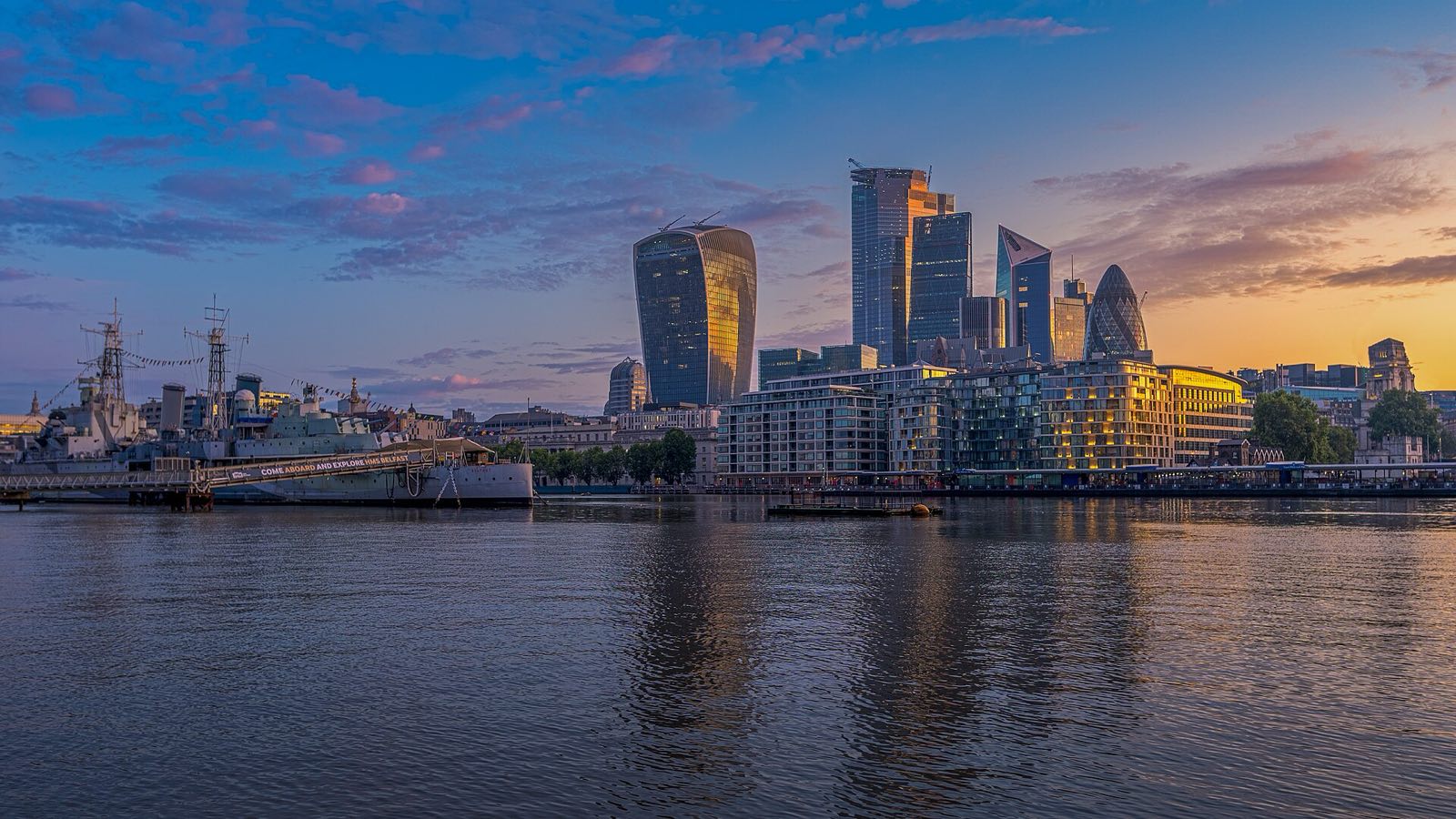 The skyline of London at dusk, seen across the Thames.