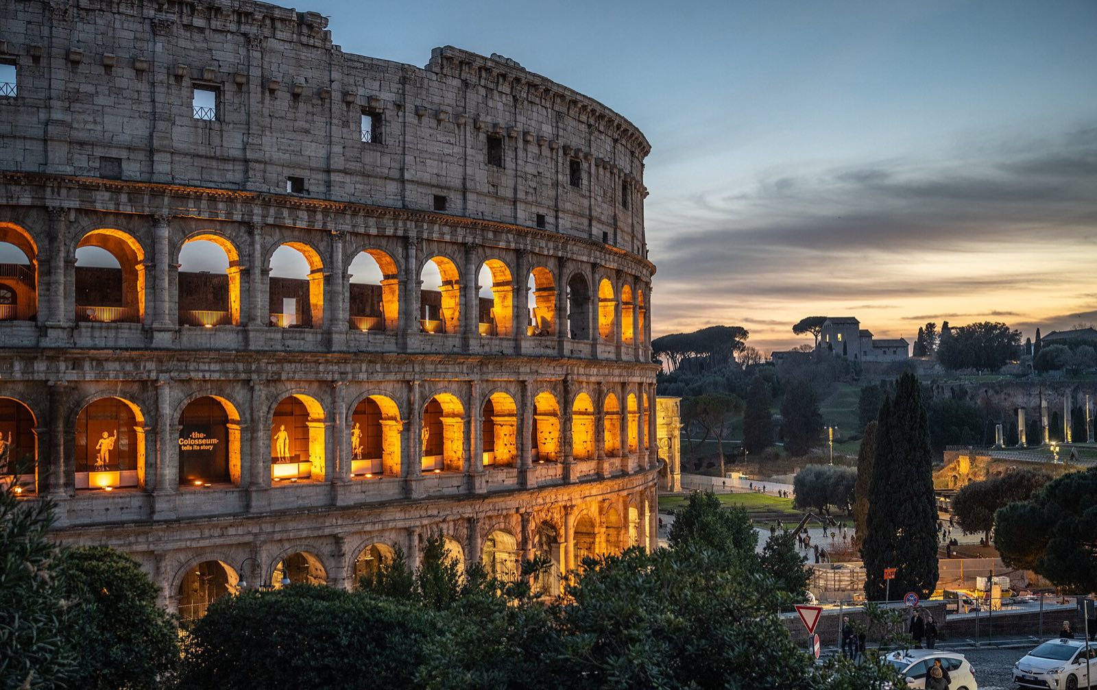 The Colosseum in Rome at dusk, its arches lit from within.
