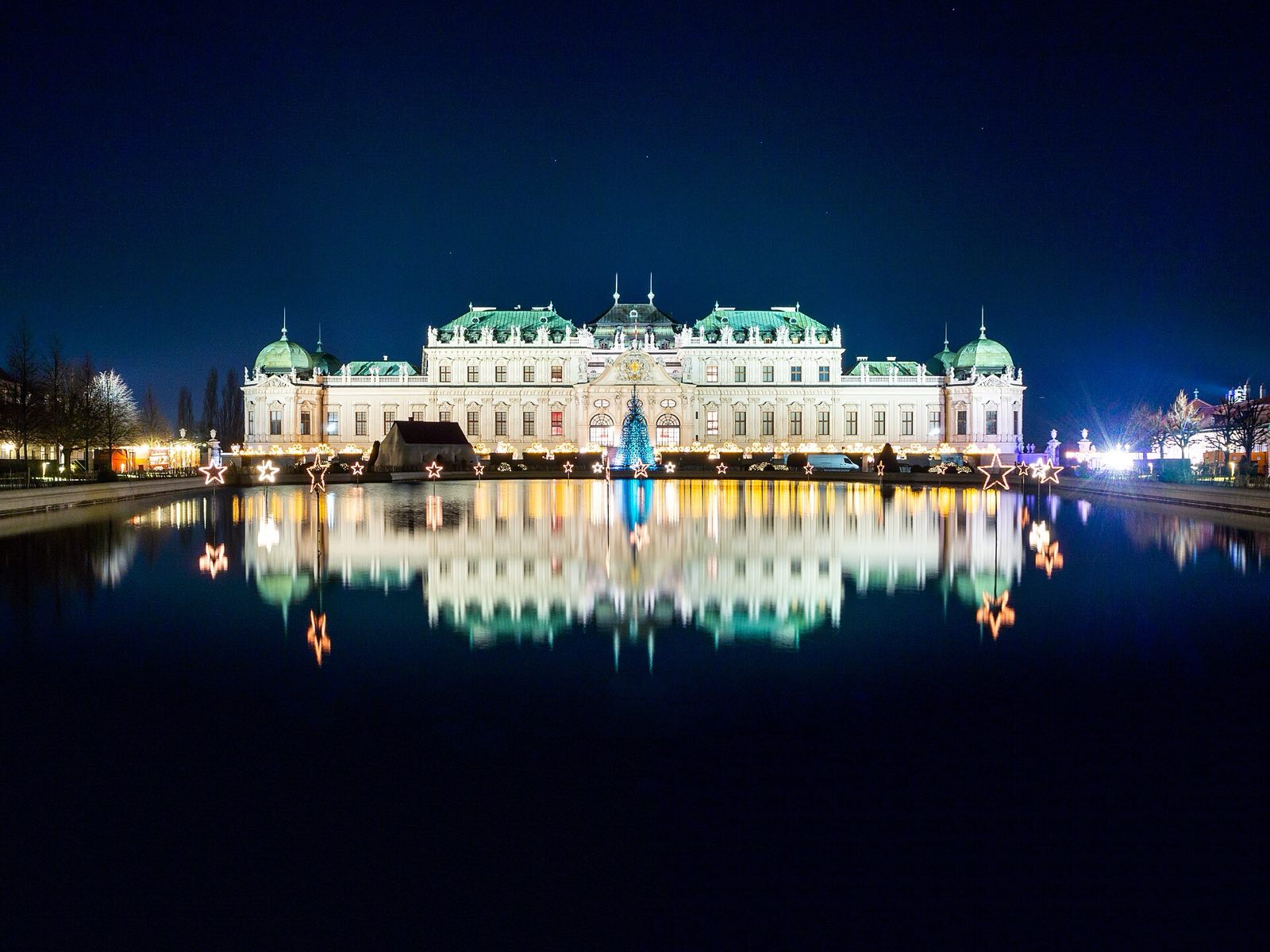 The Belvedere Palace in Vienna at night, reflected in the pool in front of it.