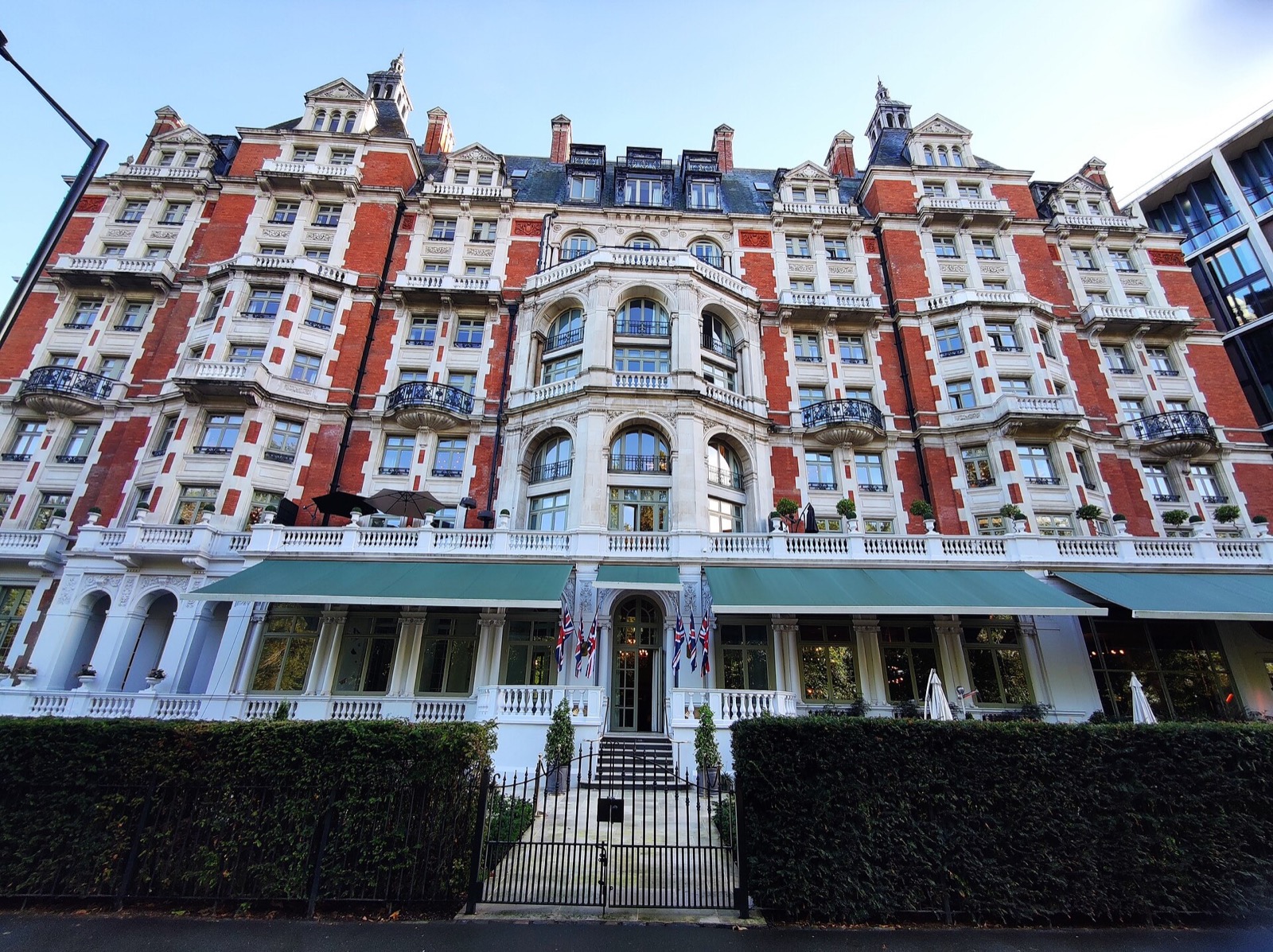 The front of the Mandarin Oriental Hyde Park, with flags over the steps to the entrance.