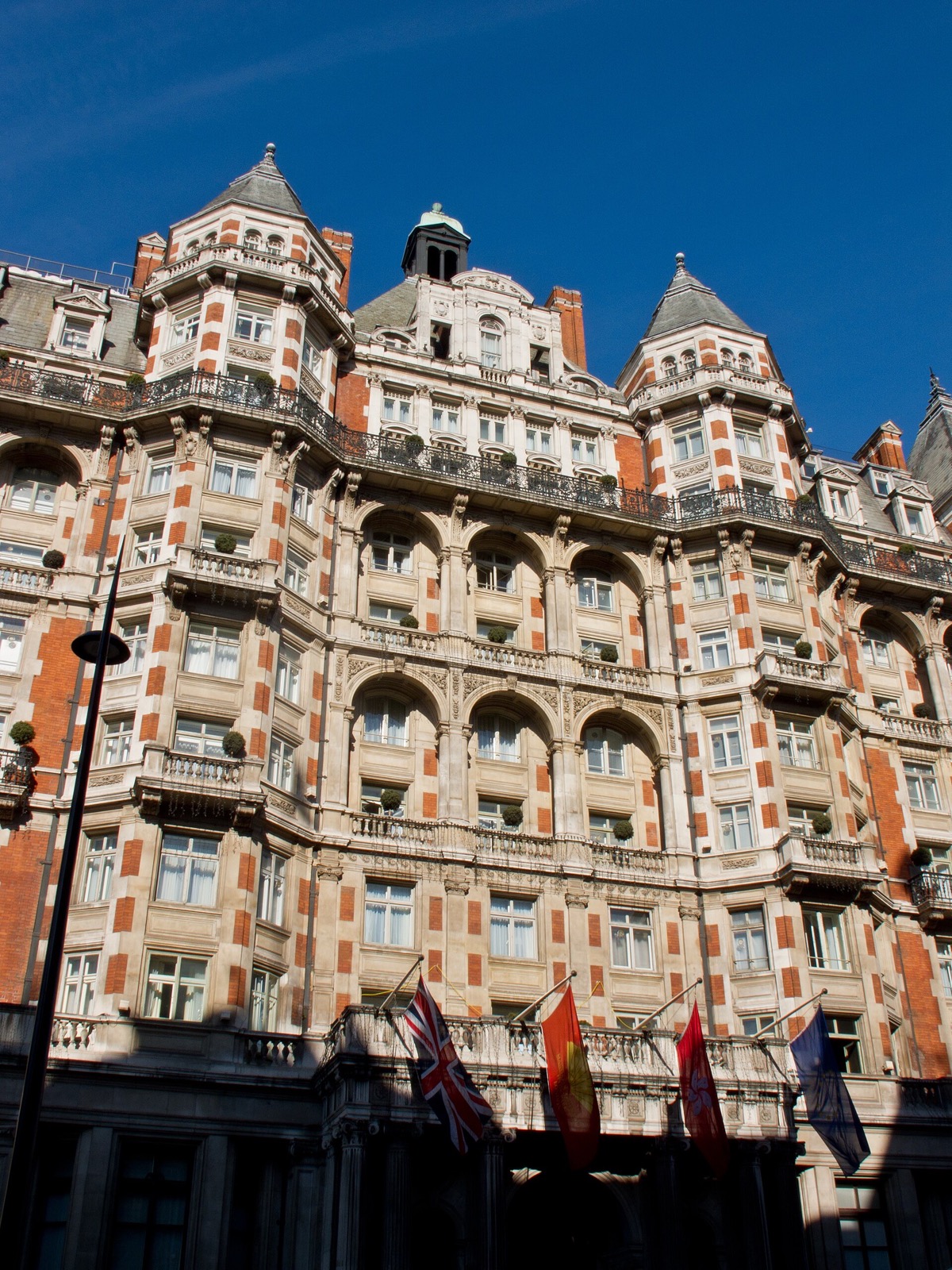 The Mandarin Oriental Hyde Park rising above Knightsbridge, its gables against a blue sky.