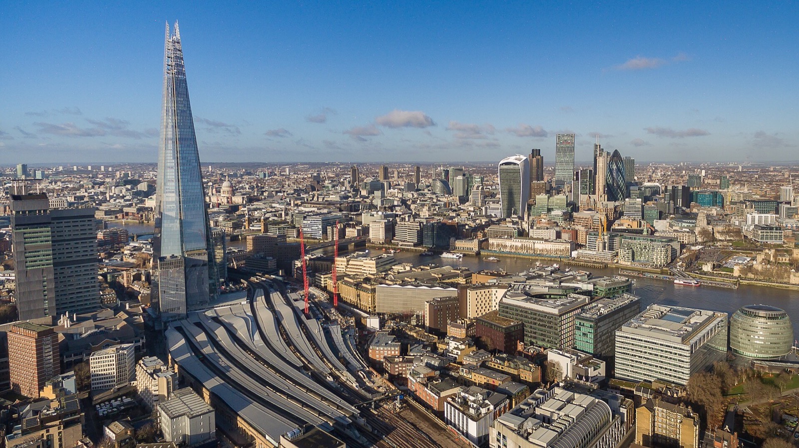 The Shard rising over London Bridge station and the Thames, seen from the air.