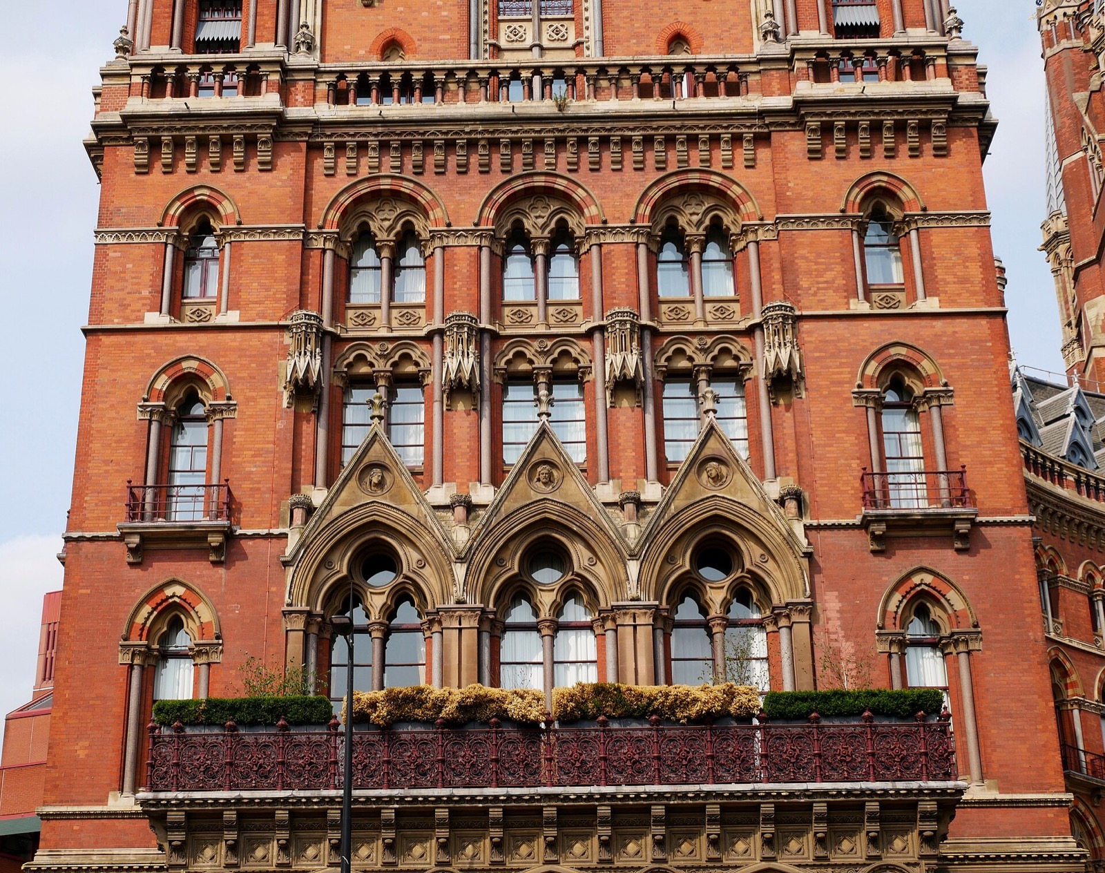 Pointed windows, balconies and stone columns on the front of the St Pancras hotel.