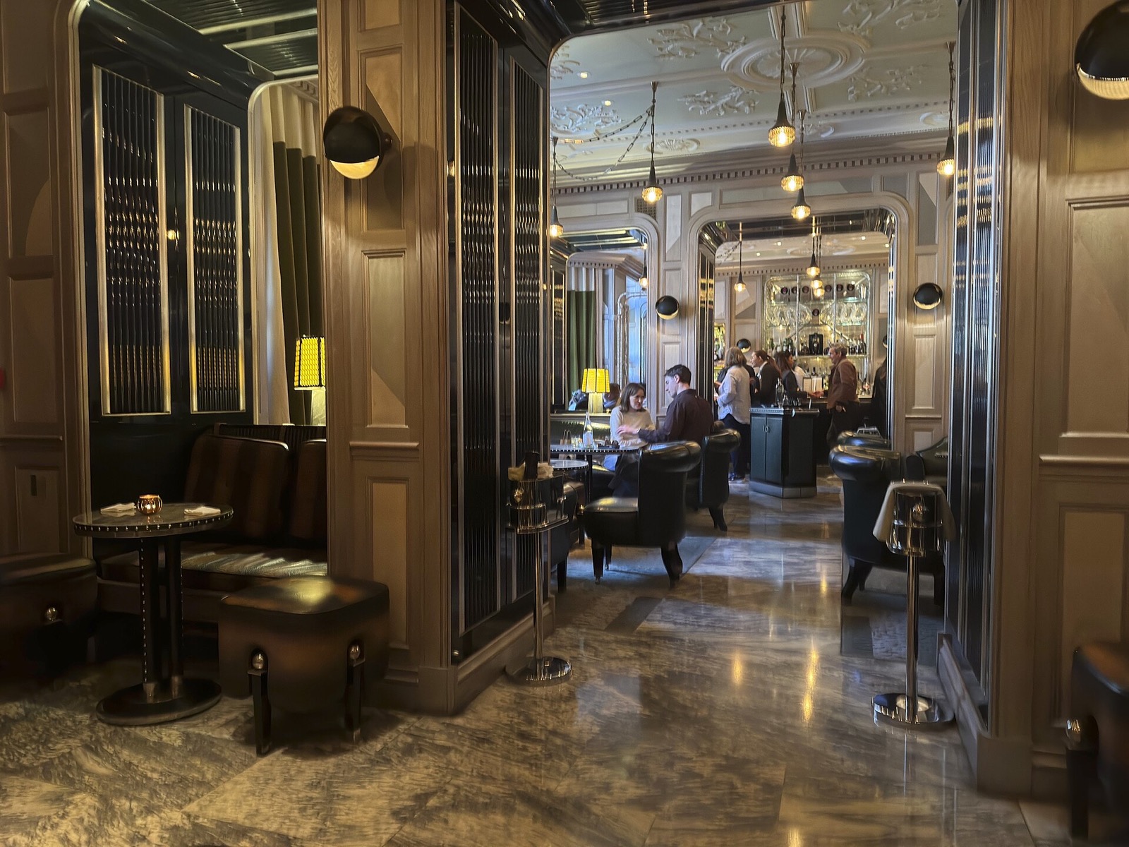 The Connaught Bar, a panelled room with leather chairs and low light.