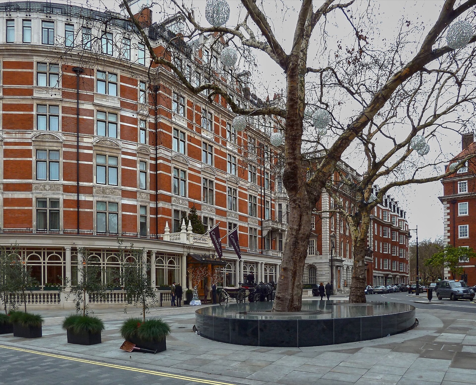The Connaught across Carlos Place, with the pool of the water sculpture Silence under two plane trees.