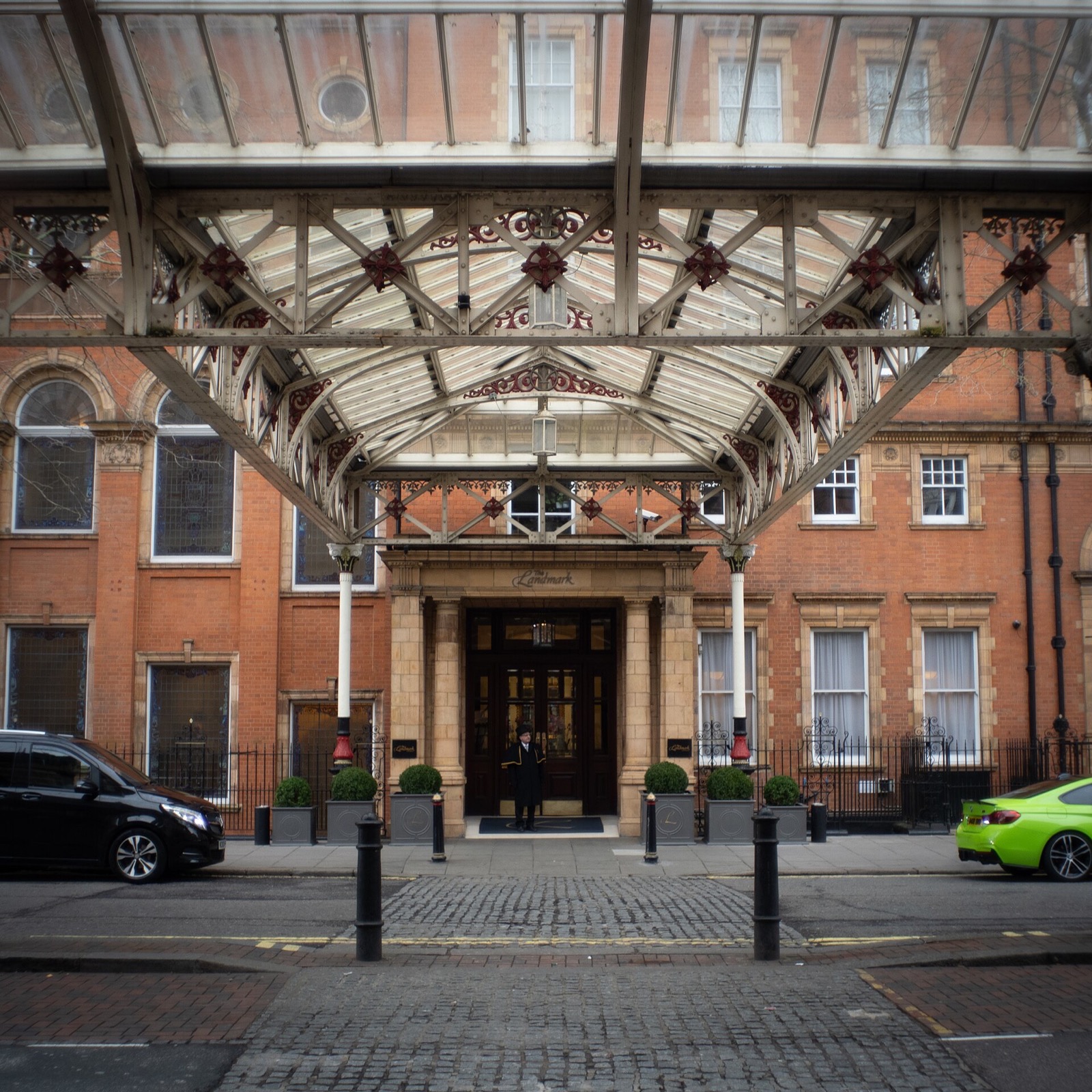 The entrance of the Landmark London seen from Marylebone station, under an iron and glass canopy.
