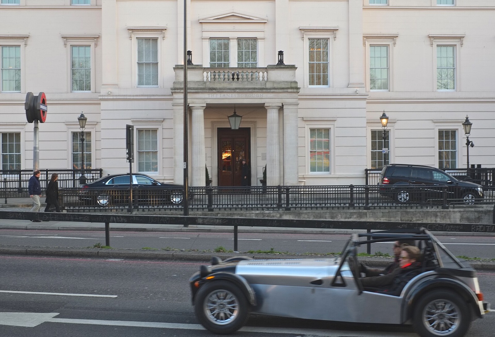 A sports car passing the white stone front of the Lanesborough.
