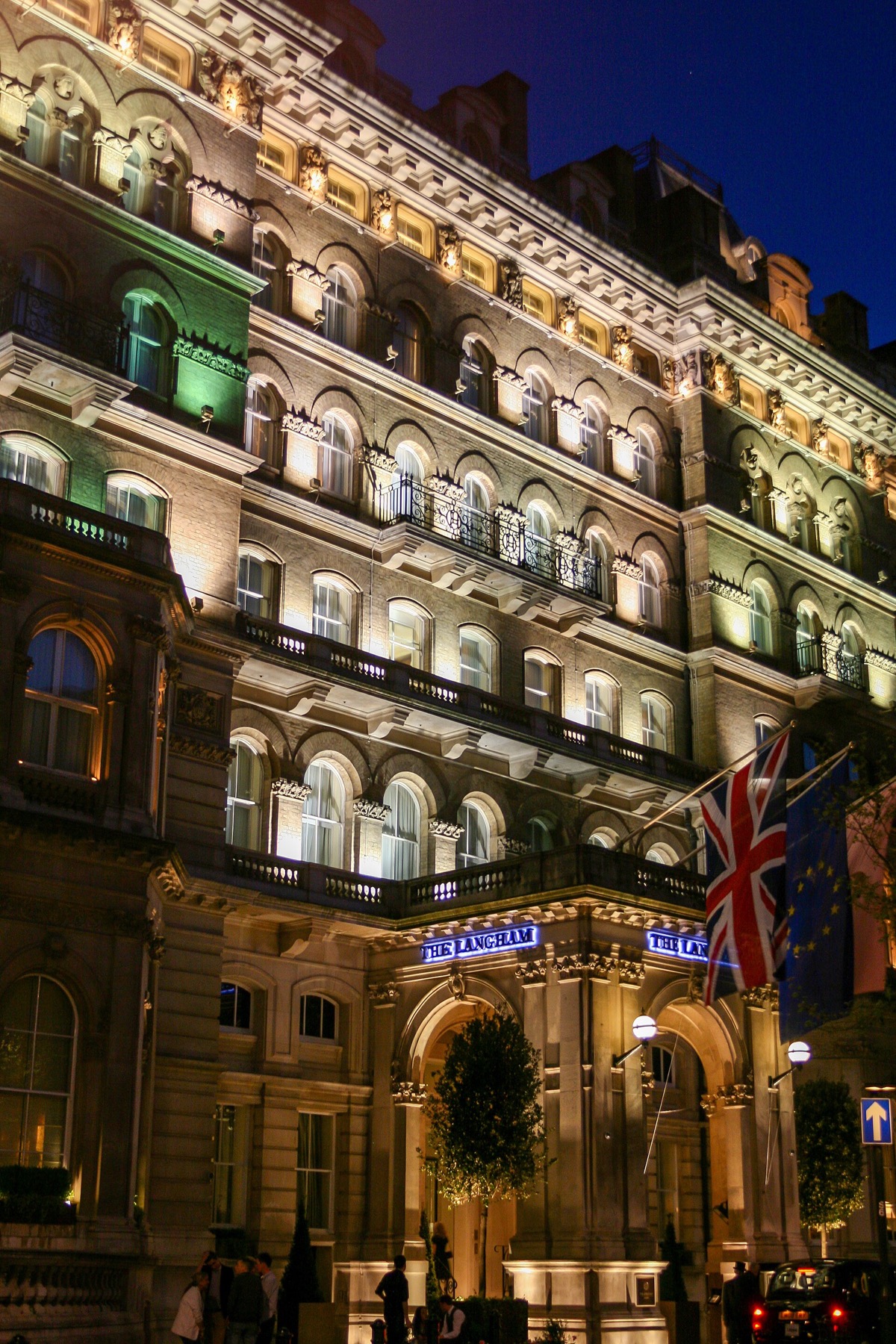 The front of the Langham lit at night.