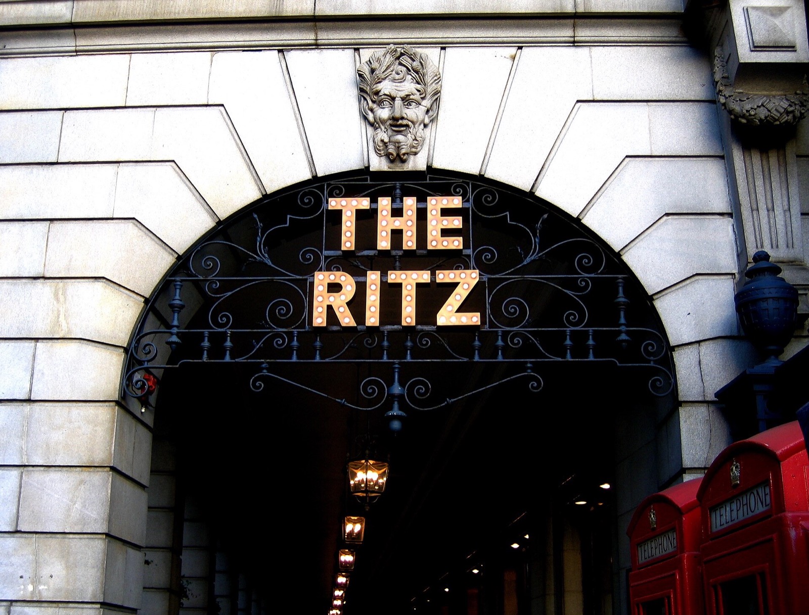 The entrance of the Ritz, with the hotel's name in lights over the arch.