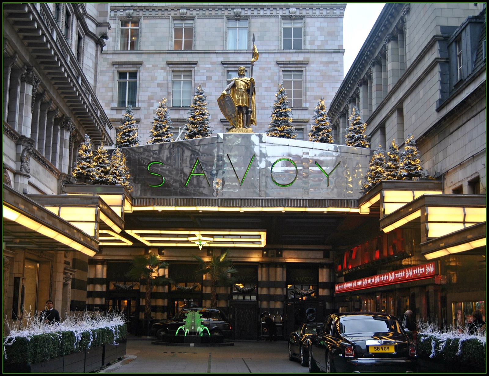 The entrance of the Savoy from the Strand, with the gilded figure of Count Peter of Savoy above the canopy.