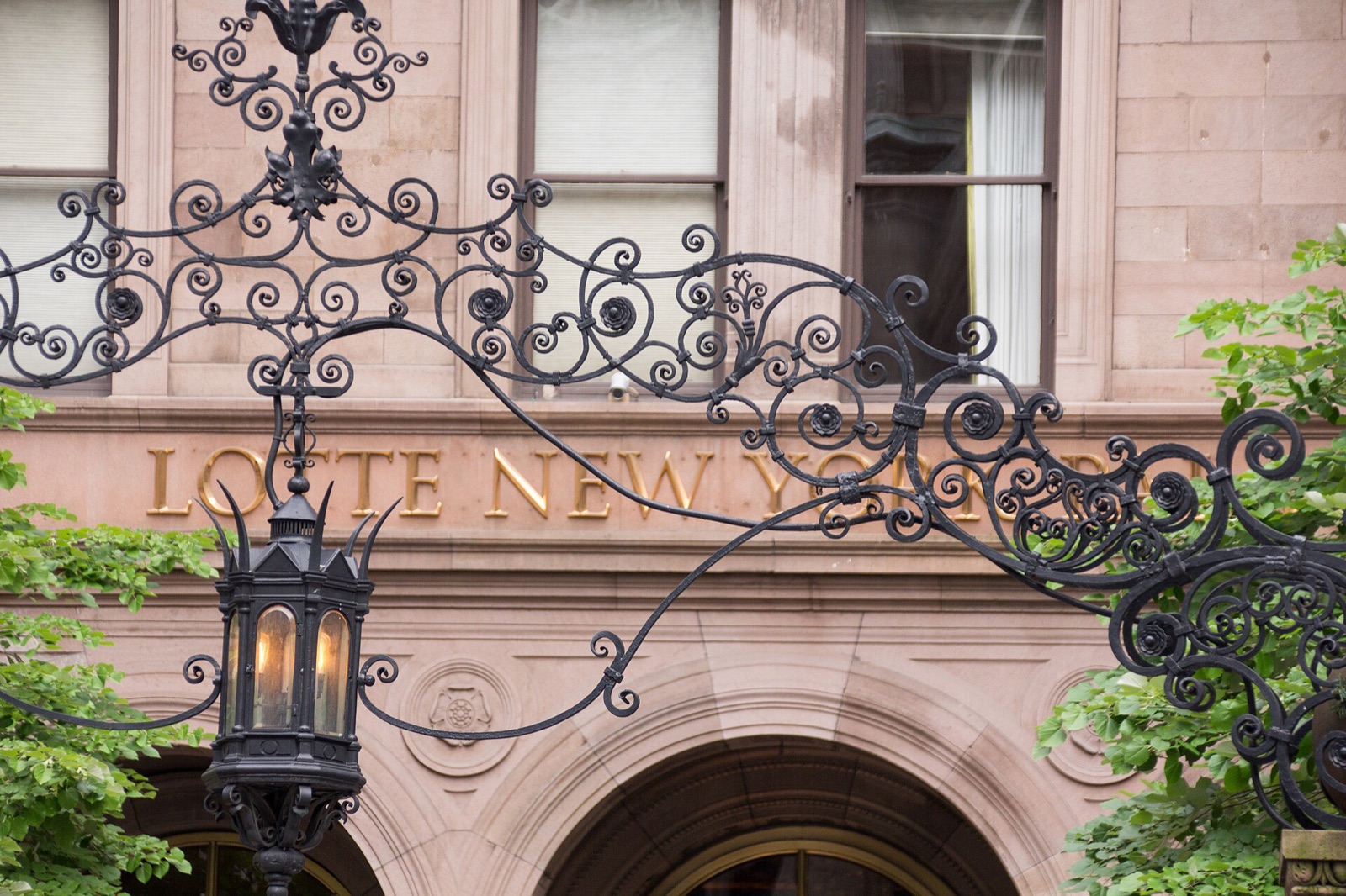 The wrought-iron gate of the Lotte New York Palace, with the hotel's name in gilt letters.