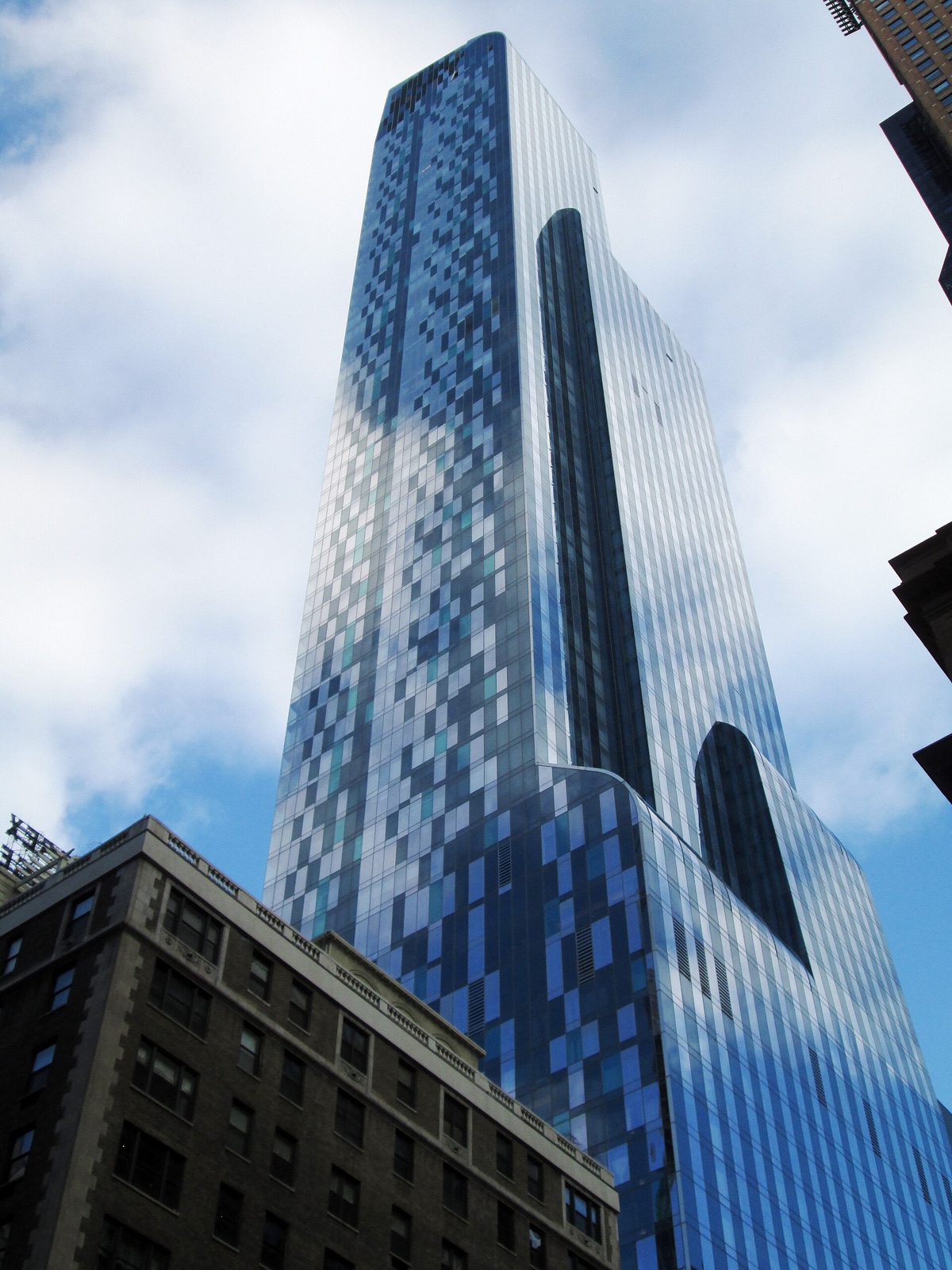 One57 from Seventh Avenue, a tower of blue glass with the Park Hyatt in its lower floors.