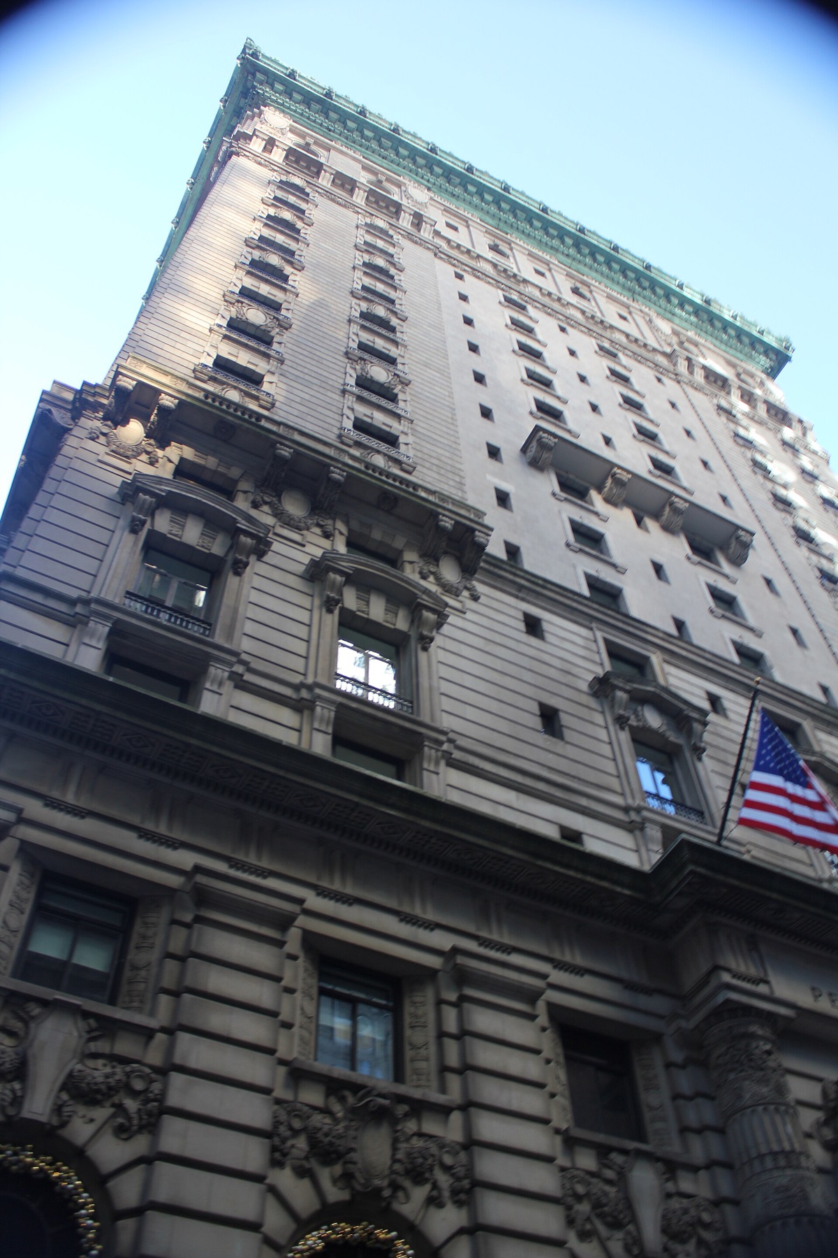 The Peninsula New York from the street, its limestone floors rising to a green cornice.