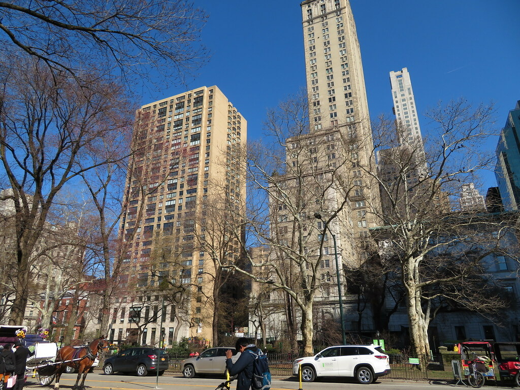 The Pierre, a tall slim tower with a copper roof, seen from the edge of Central Park.