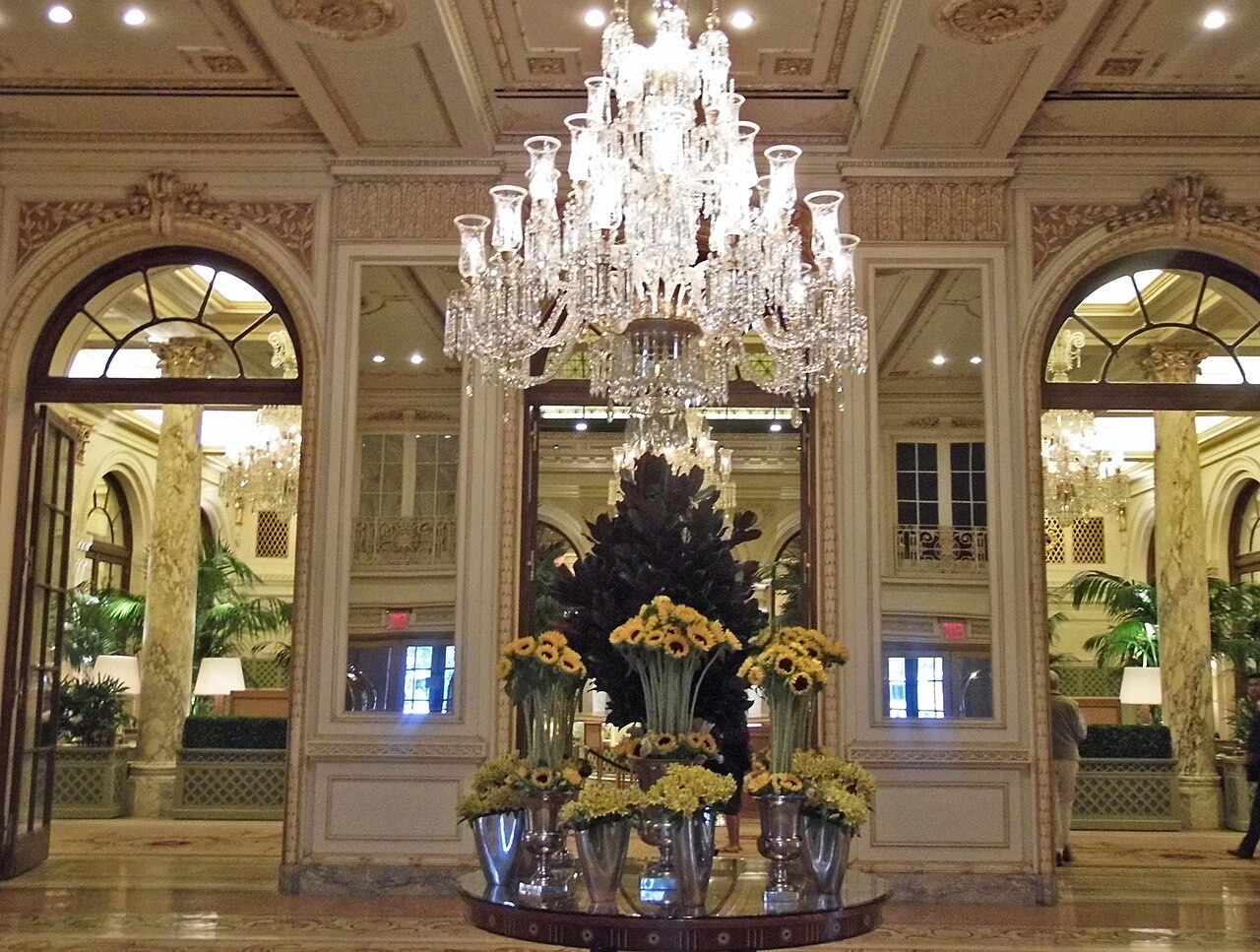 The lobby of the Plaza, with a great crystal chandelier and arched glass doors.