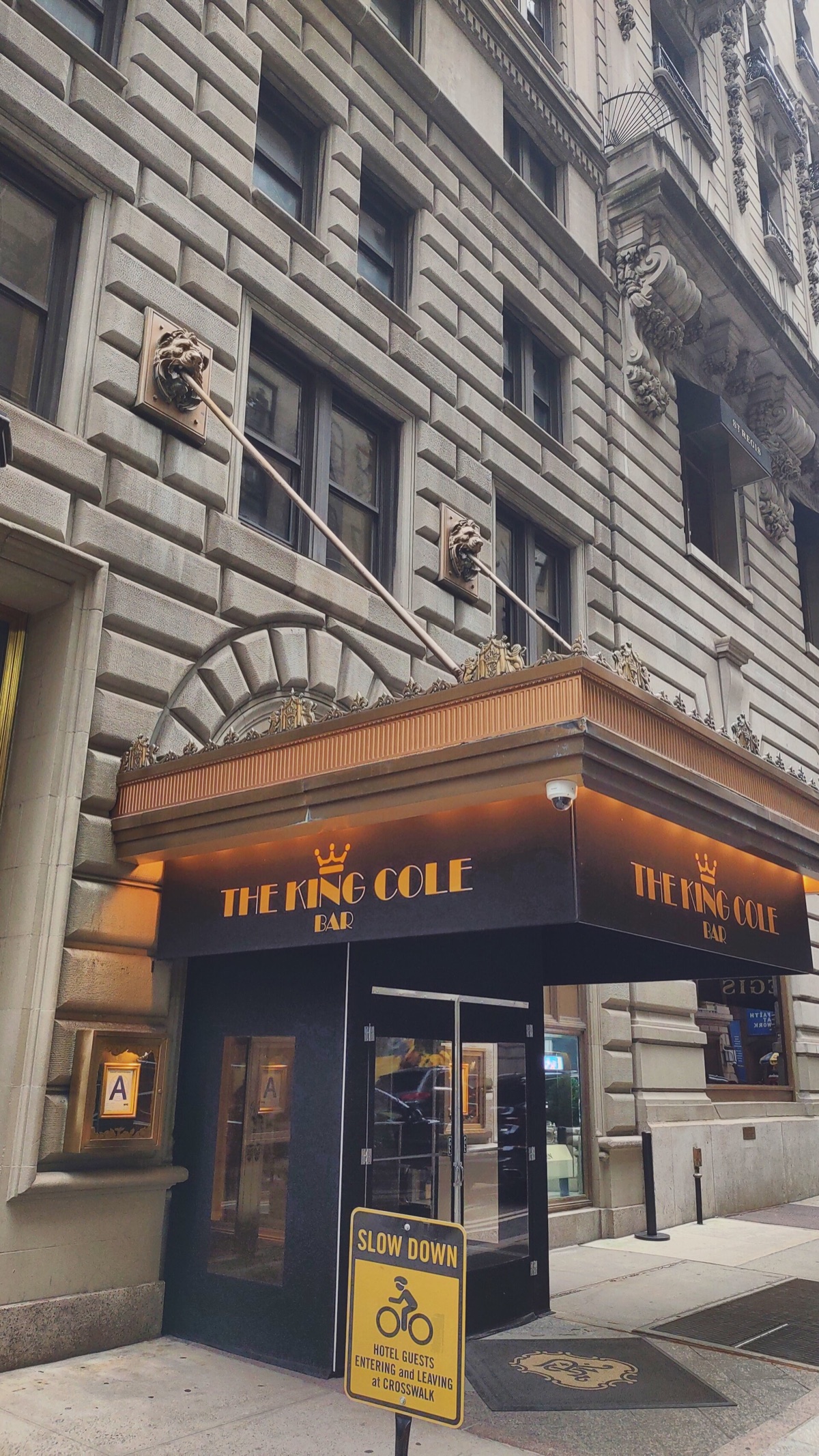 The street door of the King Cole Bar at the St. Regis, under a small canopy.
