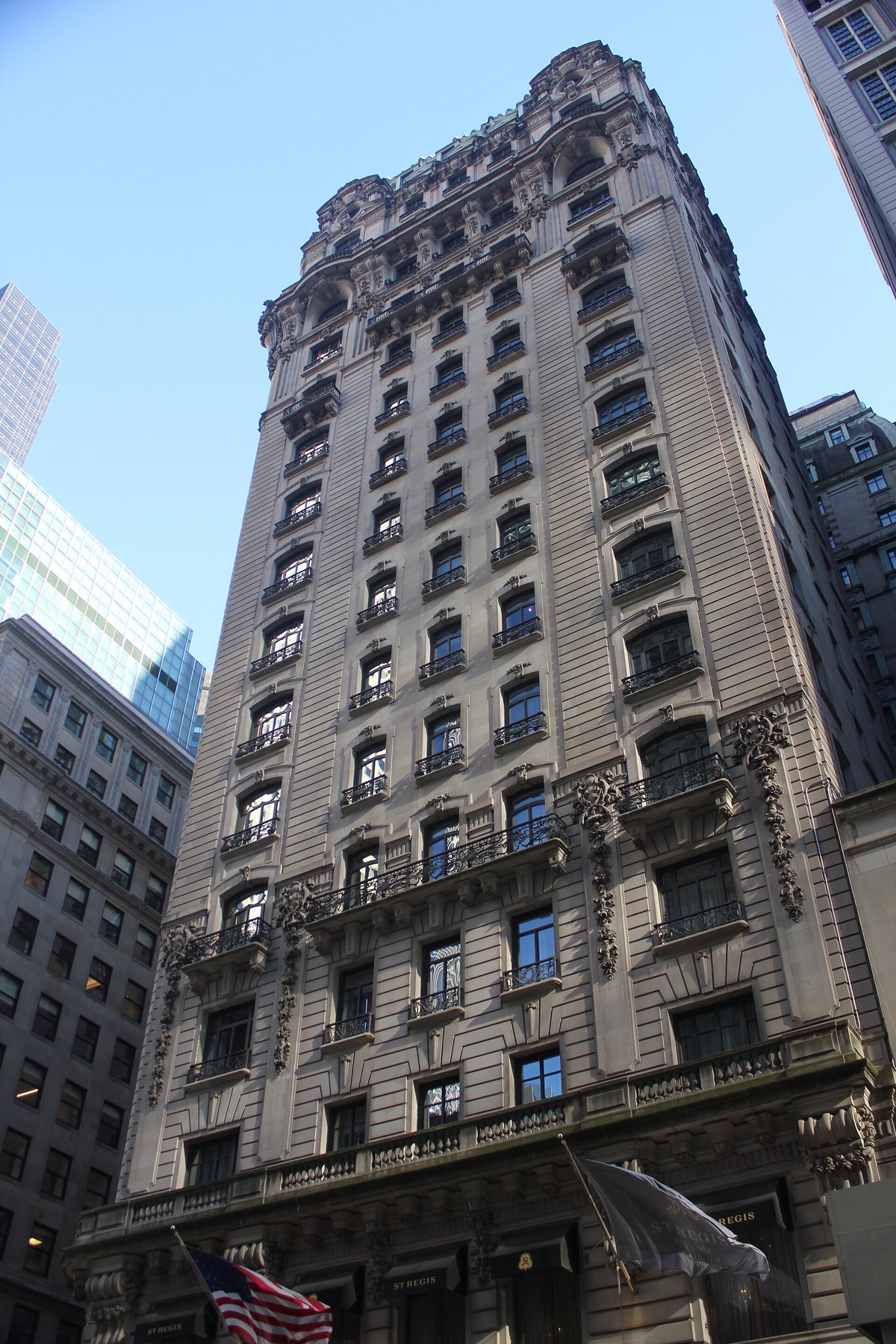 The St. Regis seen from the pavement, eighteen floors of carved stone.