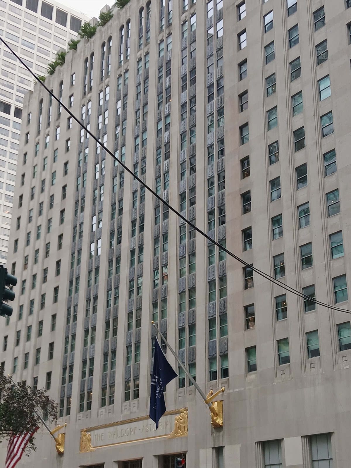 The Park Avenue front of the Waldorf Astoria, grey limestone above a bronze entrance.