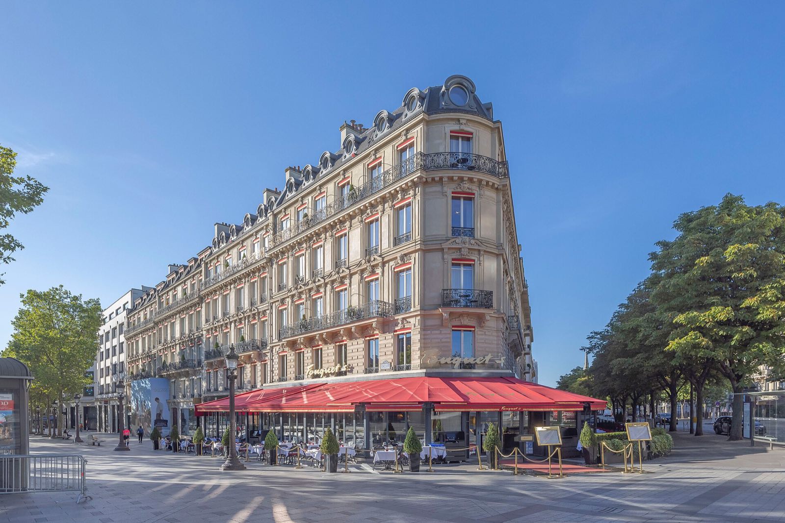 Fouquet's at the corner of the Champs-Élysées and the avenue George V, its red awnings under the stone front of the hotel.