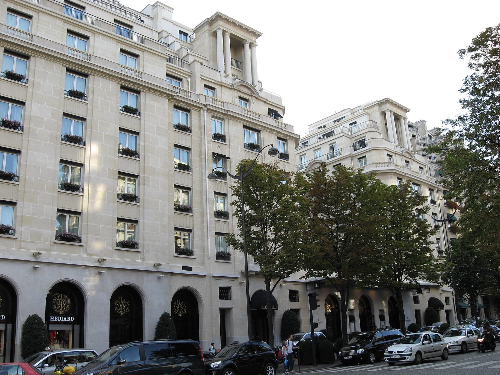 The pale stone front of the Four Seasons Hotel George V on its avenue.