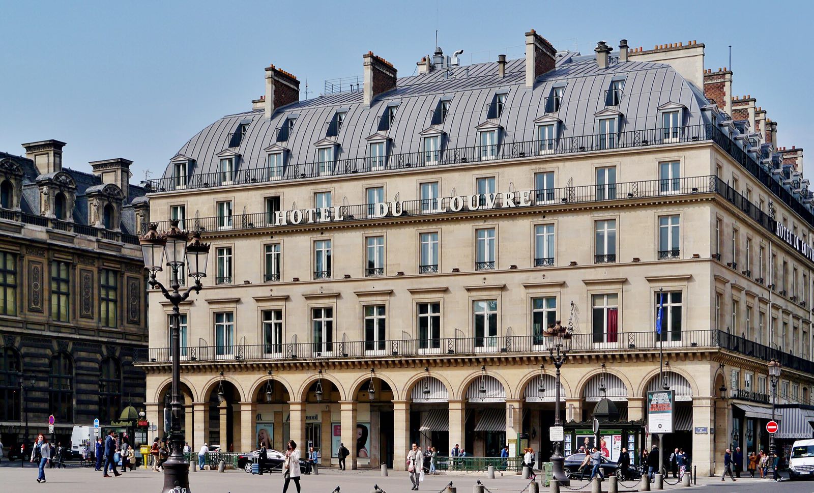 The Hôtel du Louvre, a stone block with arcades at street level and a mansard roof.