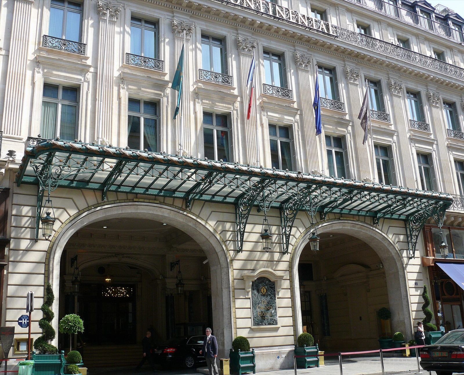 The entrance of Le Grand Hôtel on the rue Scribe, under a canopy of iron and glass.