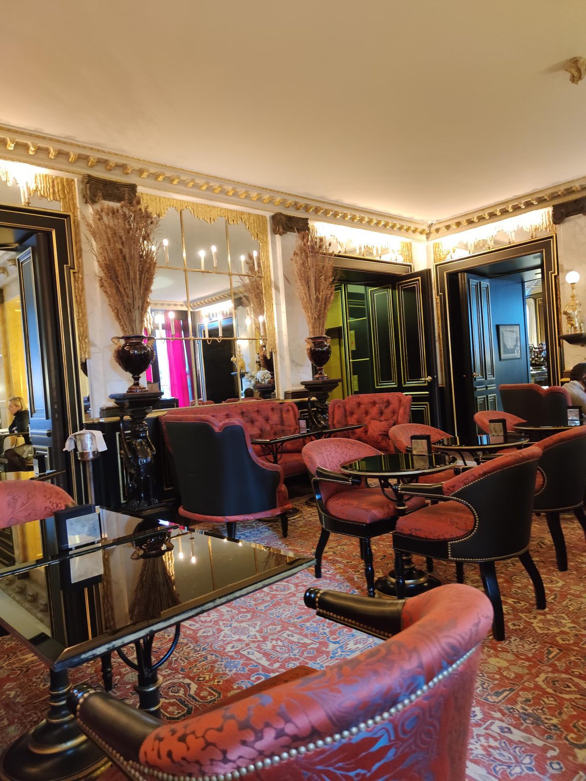 The bar of La Réserve Paris, with red velvet armchairs.