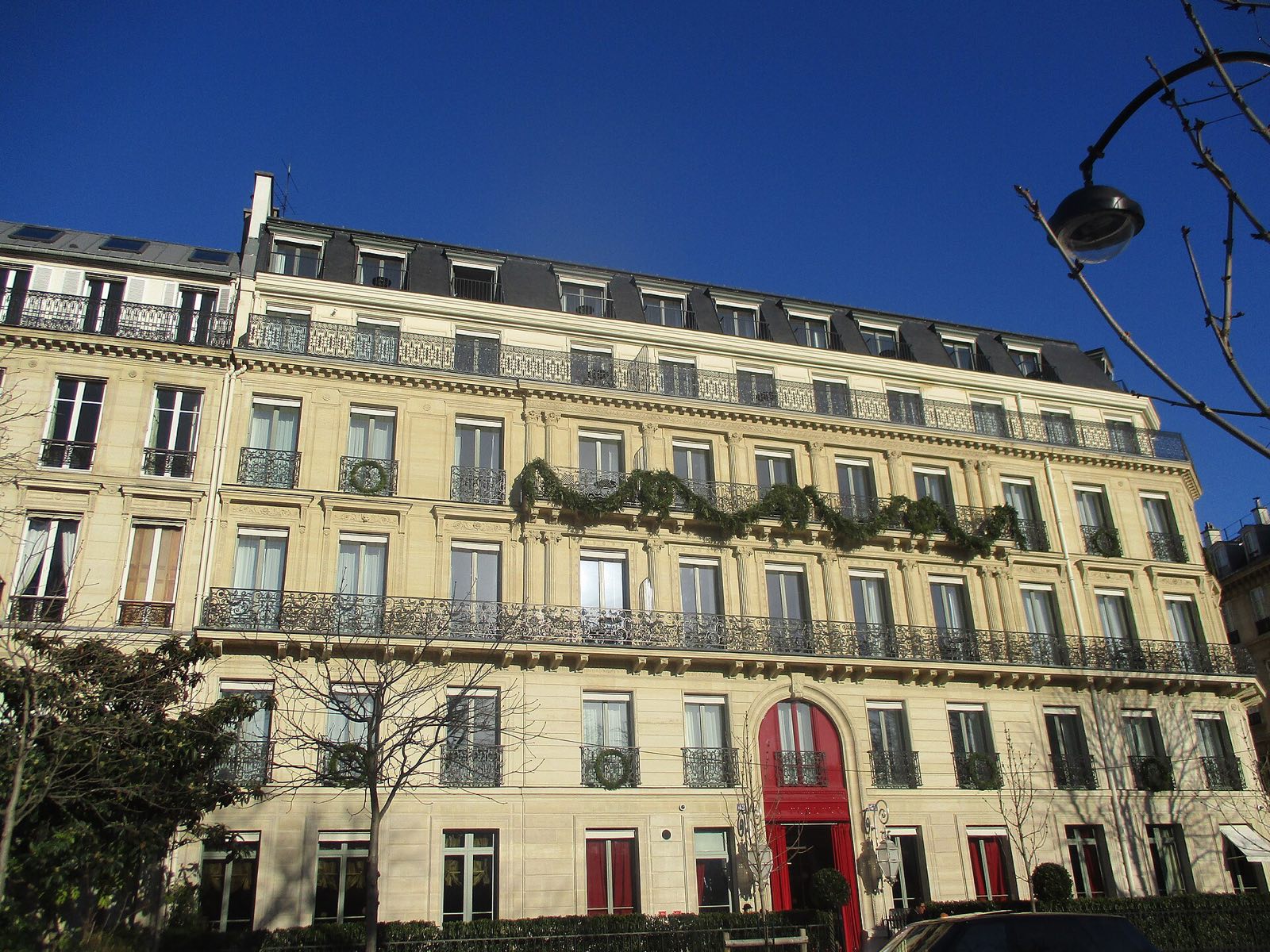 La Réserve Paris, a pale stone mansion with red doors on the avenue Gabriel.