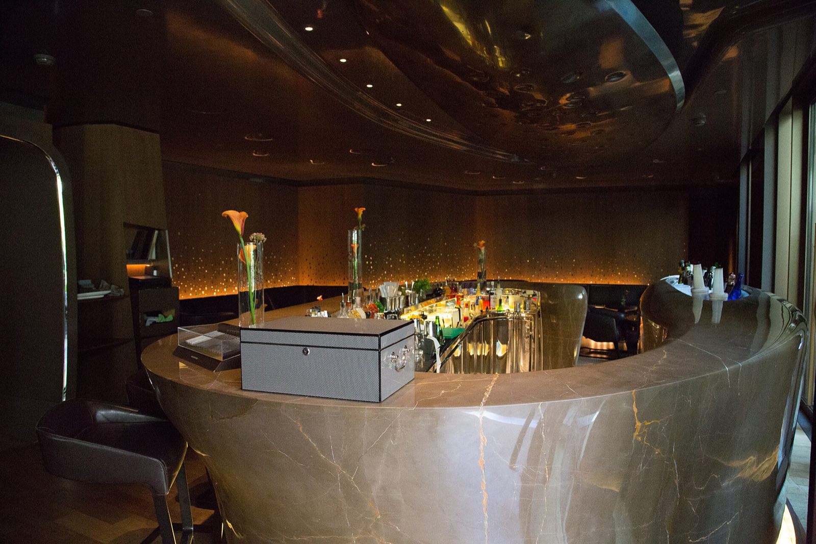The bar of the Mandarin Oriental, a curved counter of pale stone under low light.
