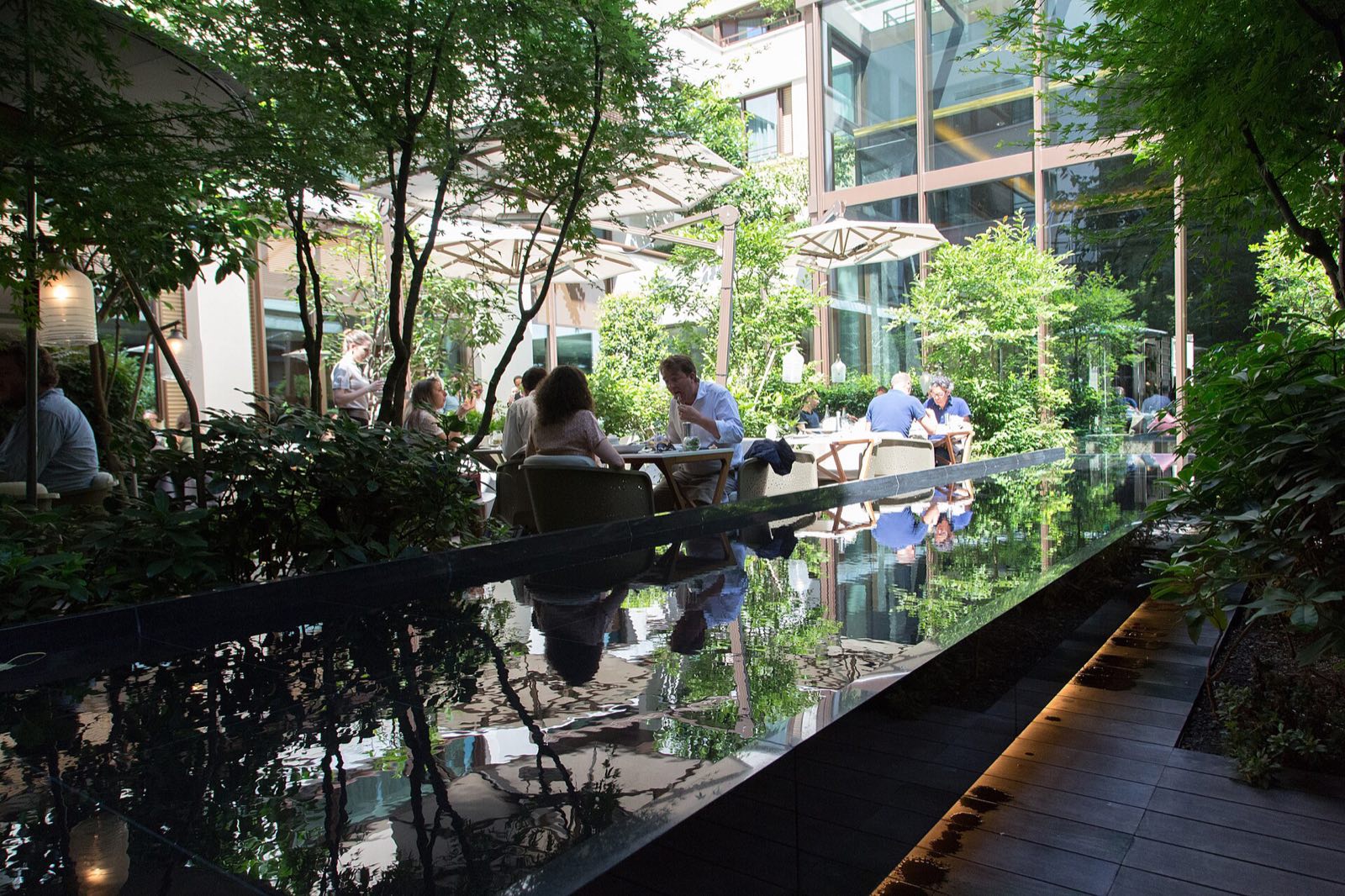 The garden at the centre of the Mandarin Oriental, with tables among the trees.