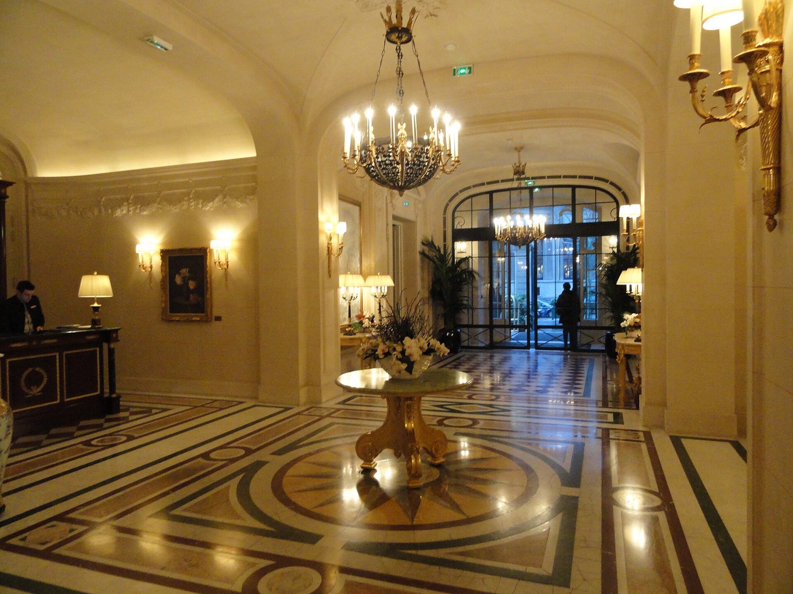 The lobby of the Shangri-La Paris, with a marble floor laid in circles and a chandelier.