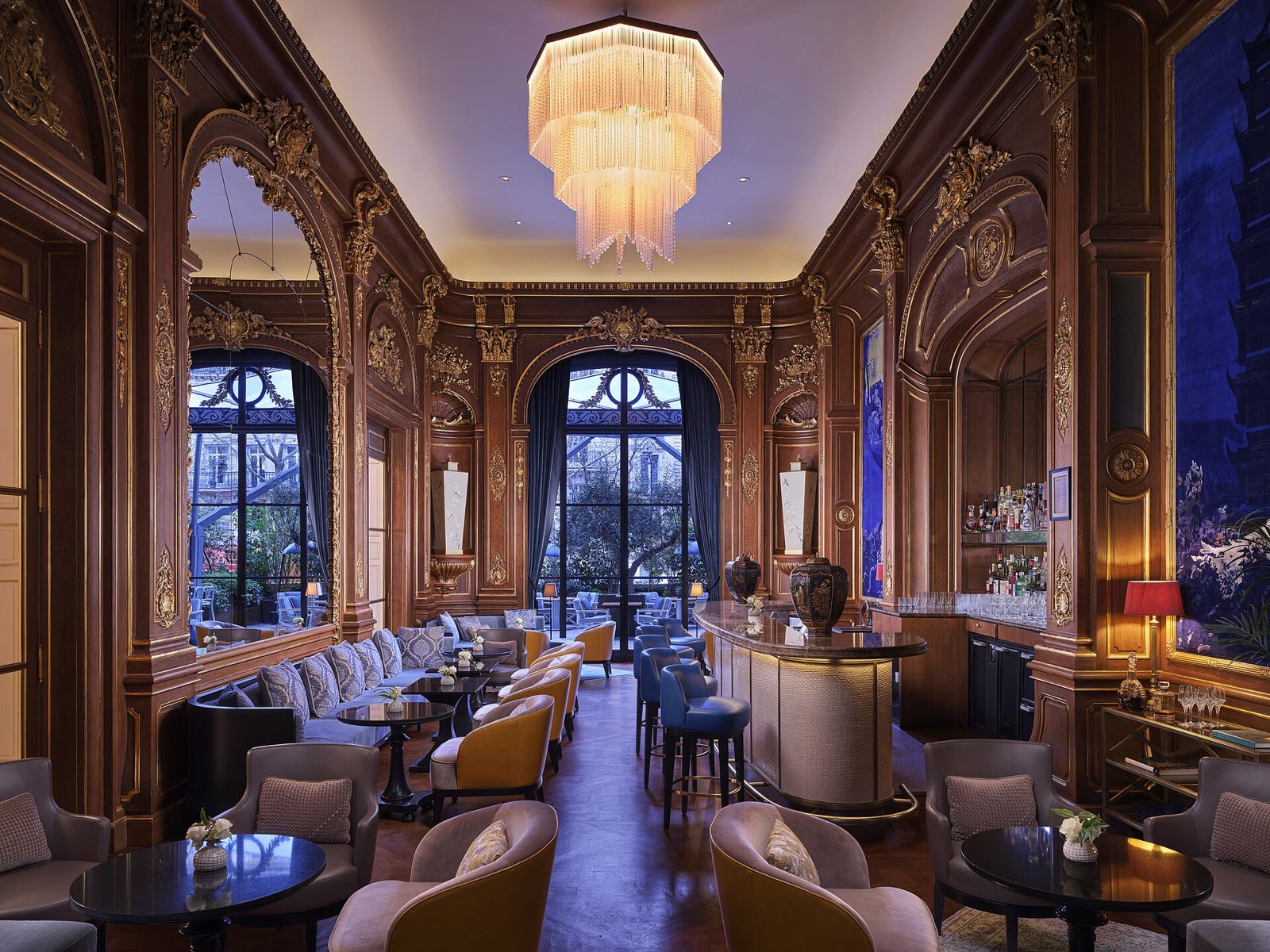 The Bar Kléber at The Peninsula Paris, panelled in dark wood under a chandelier.