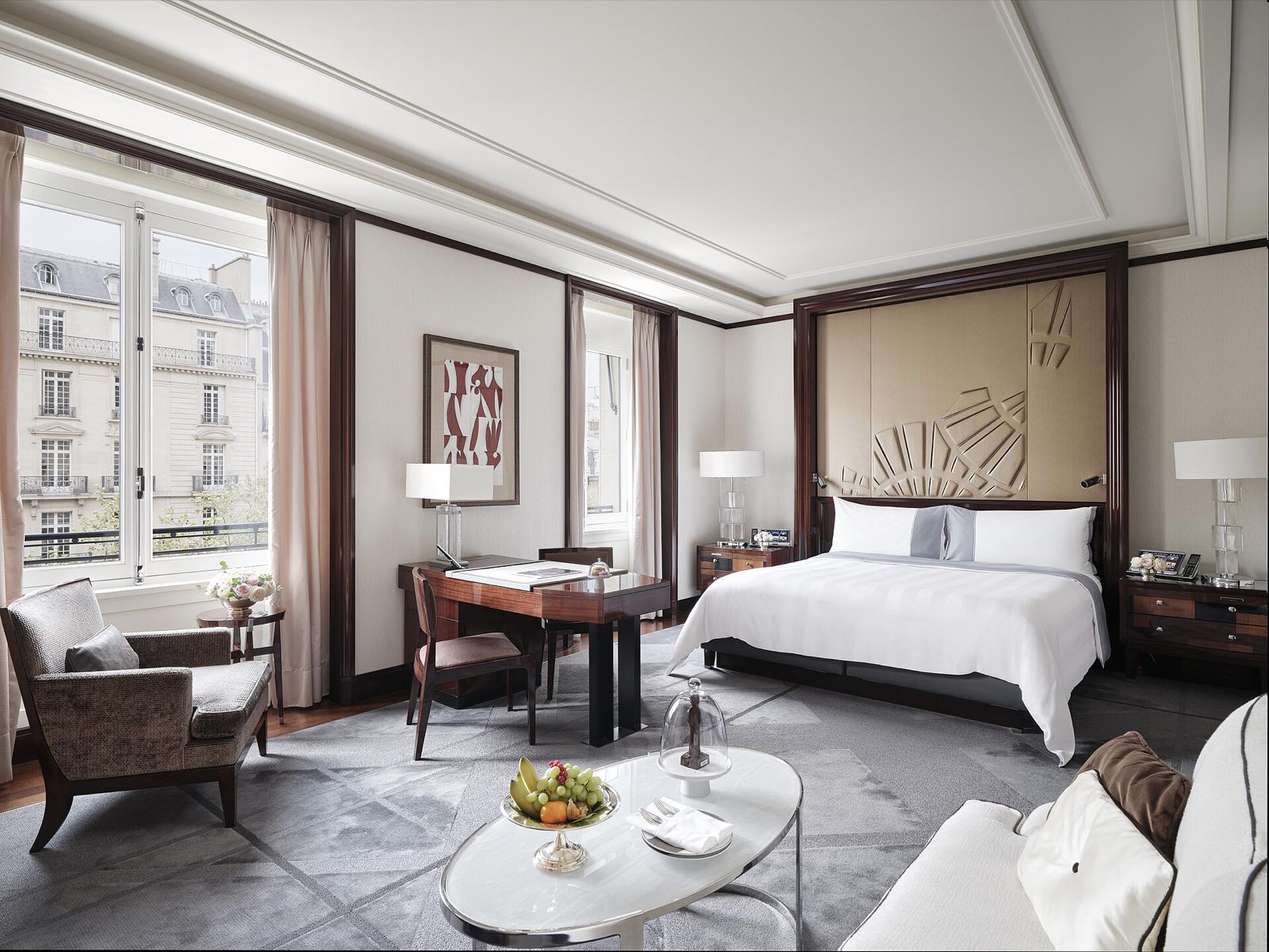 A junior suite at The Peninsula Paris, with tall windows.