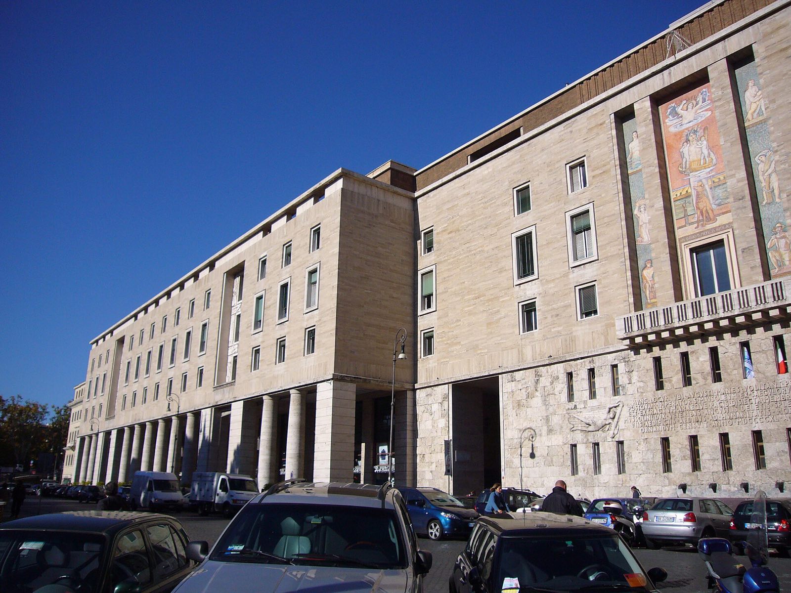 The brick and travertine building on Piazza Augusto Imperatore with a mosaic panel high on its front, photographed before it became a hotel.