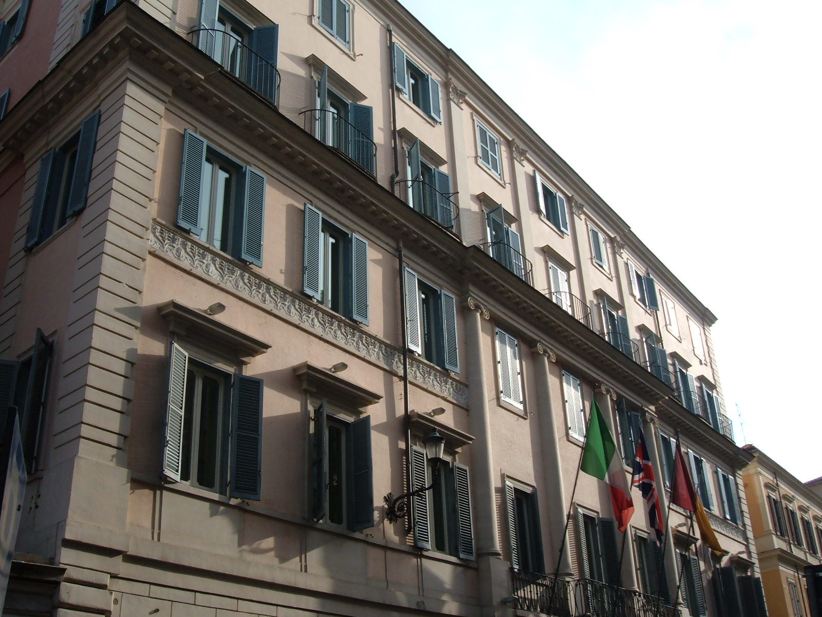 The pink front of the Hotel de Russie on Via del Babuino, with flags over the door.