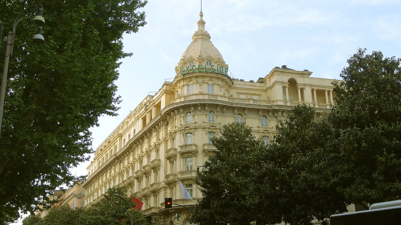 The corner cupola of the Westin Excelsior above the trees of Via Veneto.