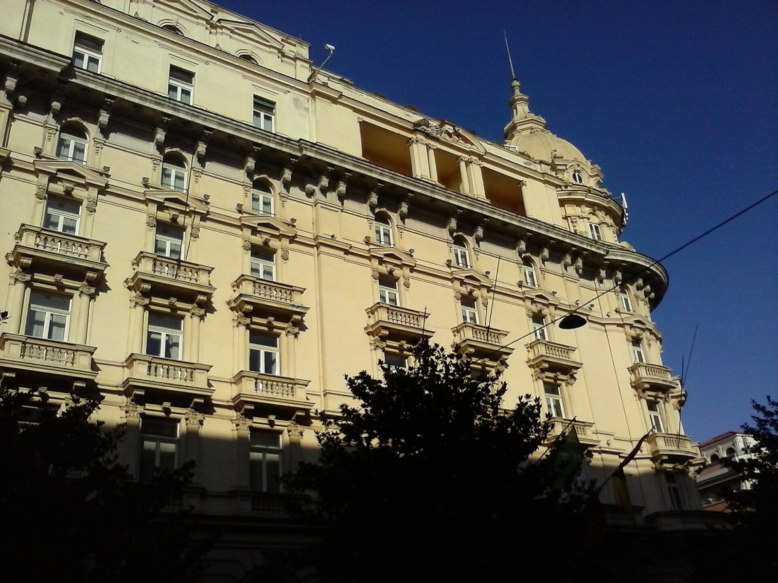 The white front of the Excelsior on Via Veneto in the evening light.